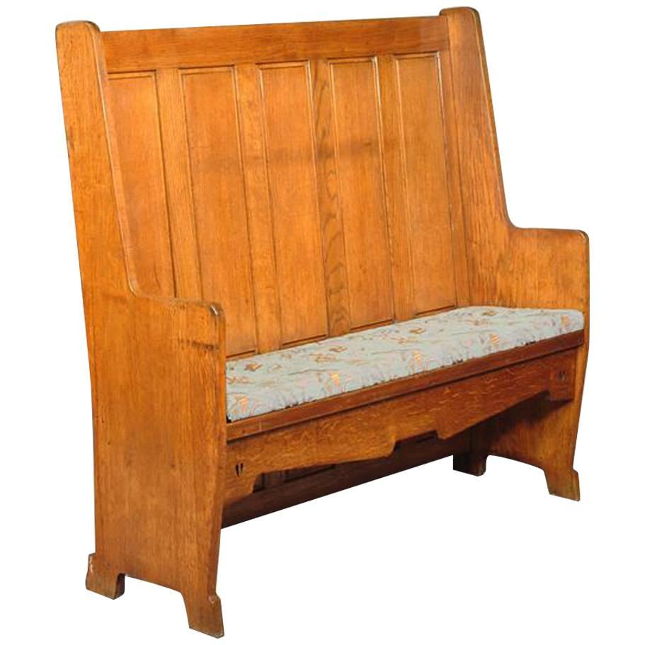 E A Taylor Attr, An Arts & Crafts Oak Panelled Settle with twin heart cut-outs.