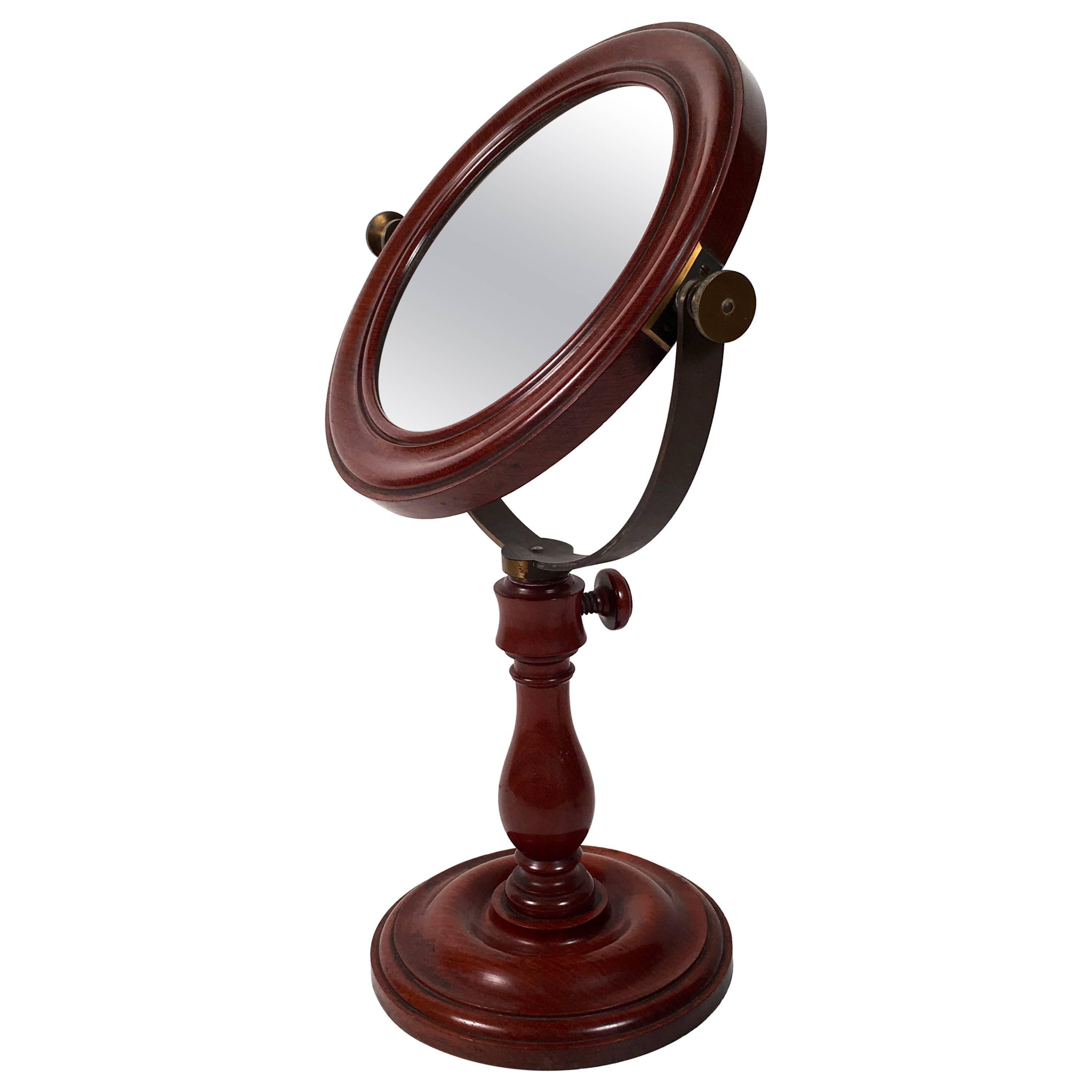 A large and beautifully made French laboratory scientific mirror in mahogany and brass, signed by maker J. Dubosco, Paris, the large circular molded bezel enclosing a high quality optical mirror, with strong magnifying power, supported on an