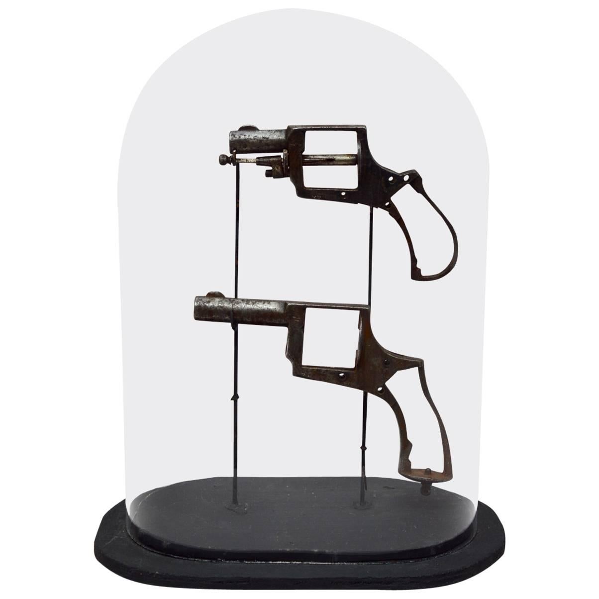 Vintage Hand Gun Frames Mounted on Stands and Presented in a Glass Dome