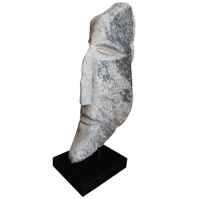 Elongated carved stone head, 2005, by Ted Ludwiczak 