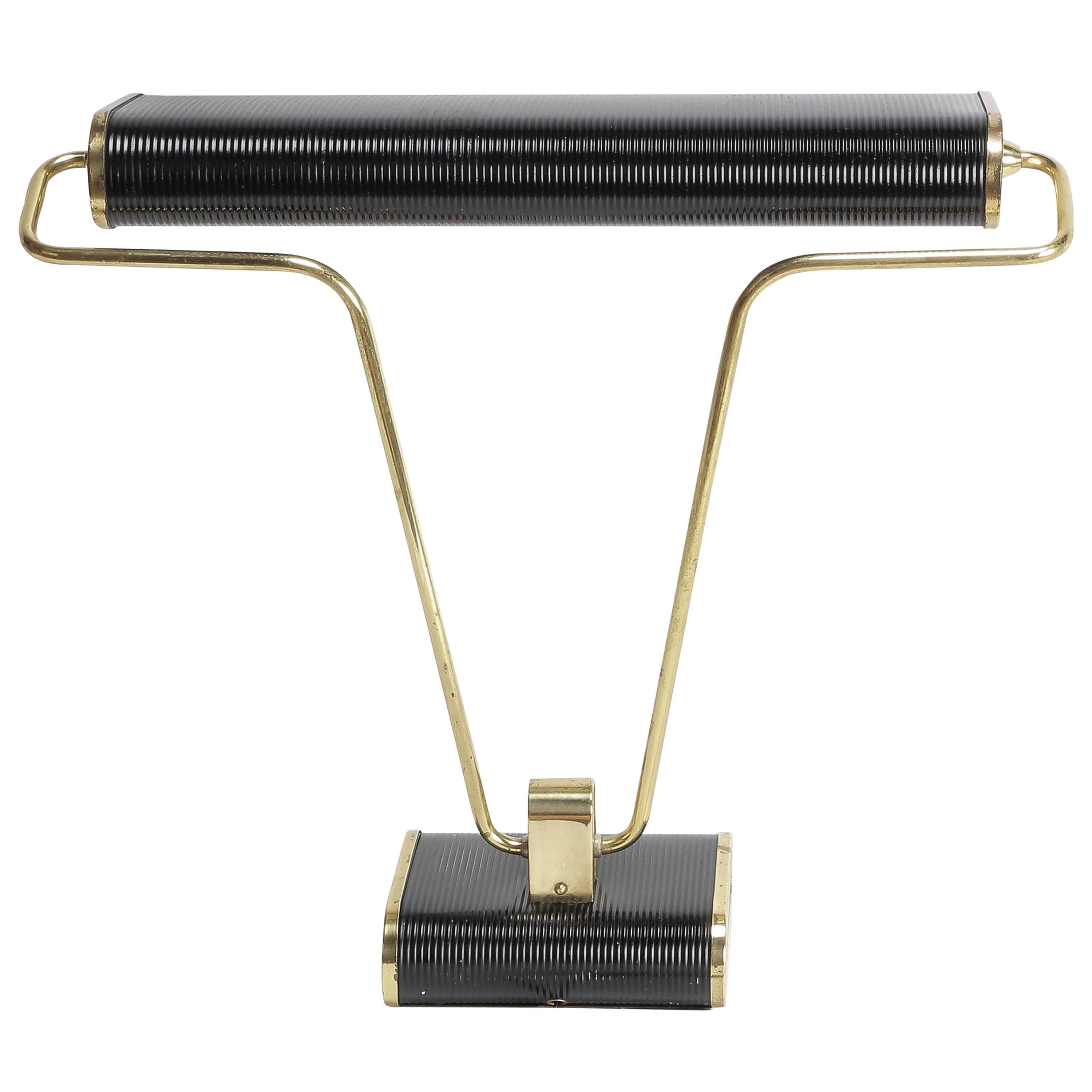 Eileen gray desk lamp for the French manufacturer jumo in the early 1940s. Adjustable arm and shade in black lacquered metal and brass. Two-light bayonet bulbs, switch is located on base.