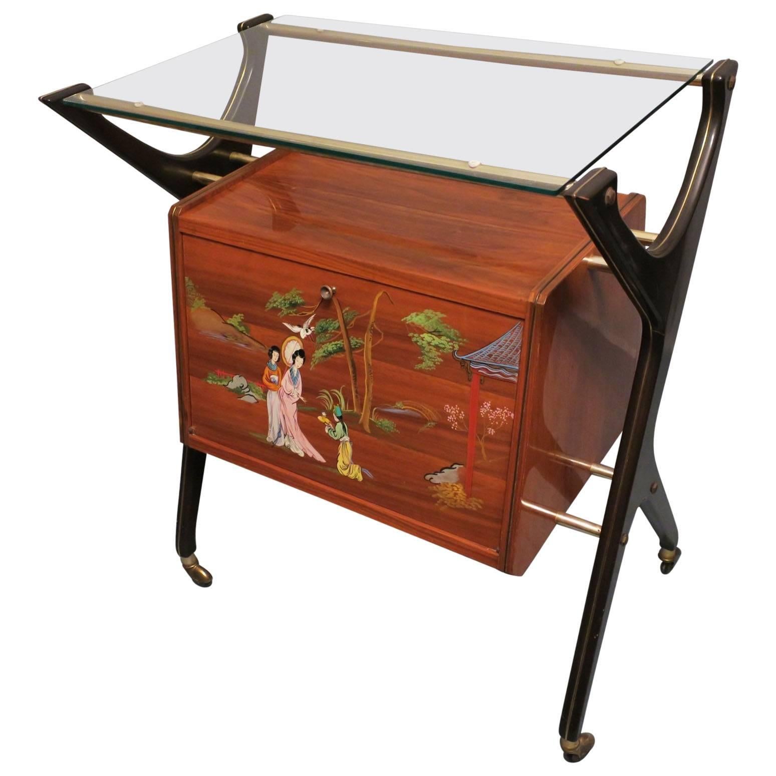 Italian bar cart or dry bar from the 1950s with a bright yellow interior. On the outside are painted Japanese figures.
The bar lights up automatically on opening the door flap.