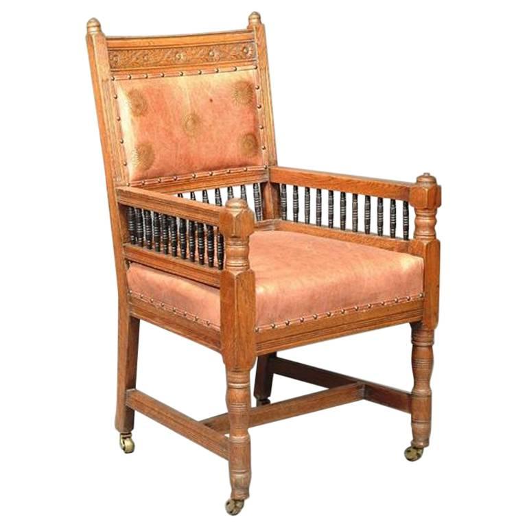 E W Godwin. An Aesthetic Movement Carved Oak Armchair with Ebonized Spindles