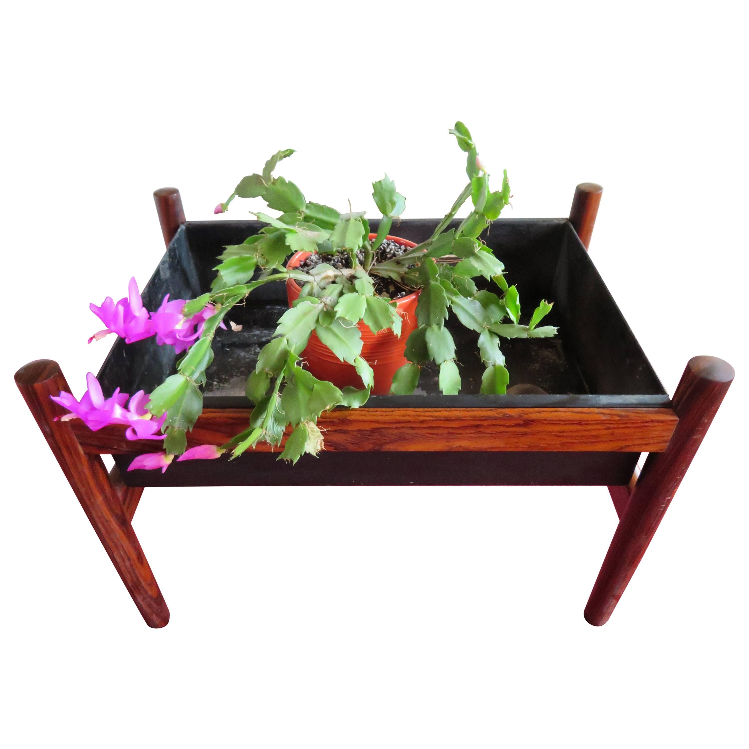 Danish modern rosewood planter with label. Classic Minimalist rosewood frame with black metal insert.