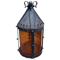 Une grande lanterne en fer Arts and Crafts conservant l'abat-jour d'origine en ambre décapé.
