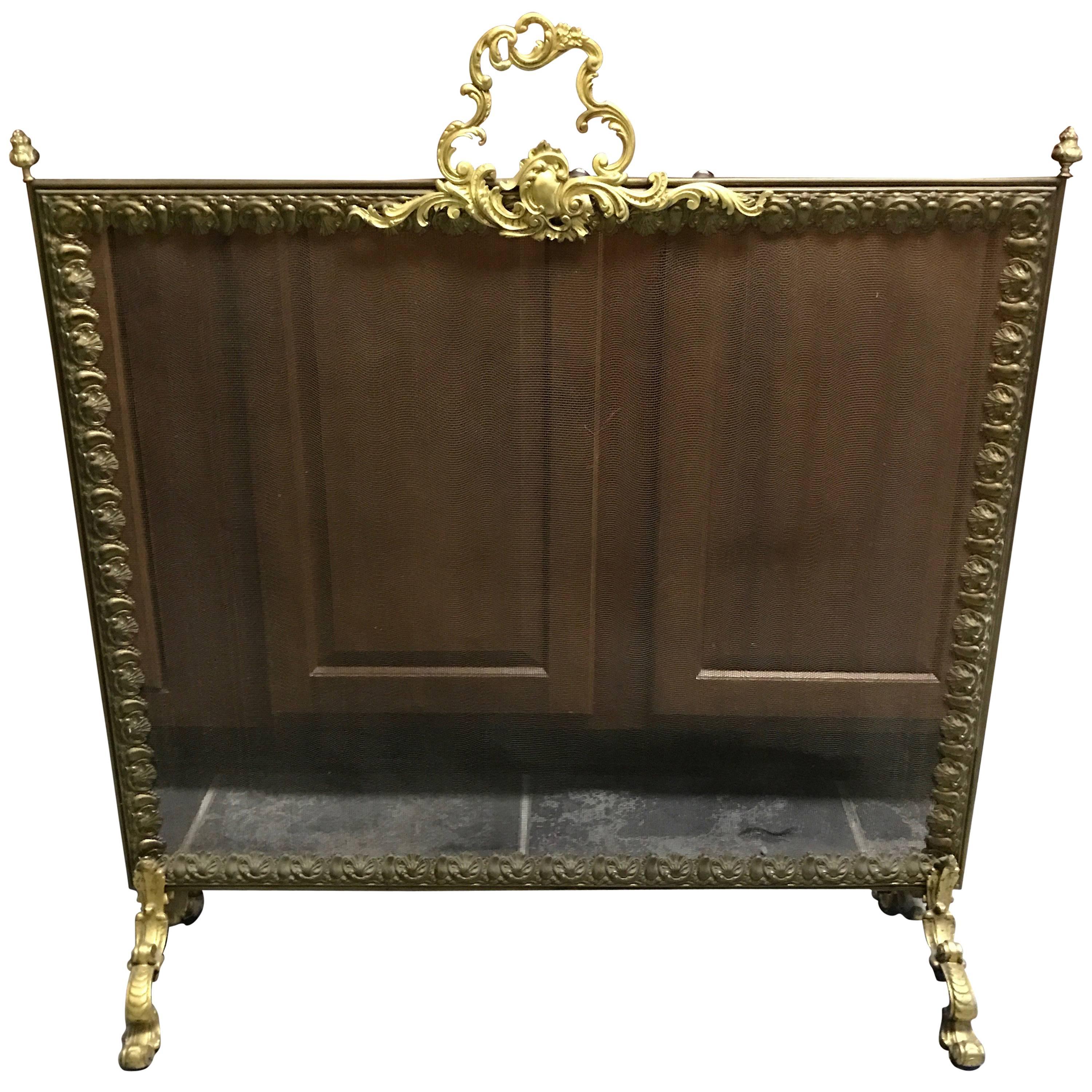Absolutely beautiful fireplace screen having detailed fancy bronze periphery, ornate dolphin motif feet, pine cone finials and doré bronze handle on top.