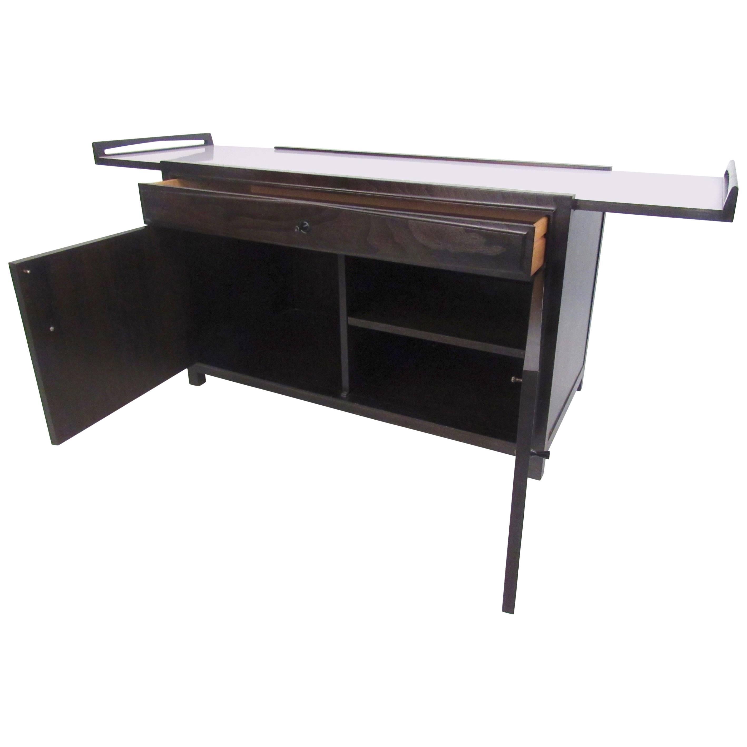 Dieser einzigartige Mid-Century-Barschrank verfügt über eine erweiterbare Formica-Platte mit erhöhten Rändern, geräumige Ablageflächen und eine breite Schublade zum Ordnen von Gläsern oder anderen Gegenständen. Hergestellt von John Kapel für Glenn