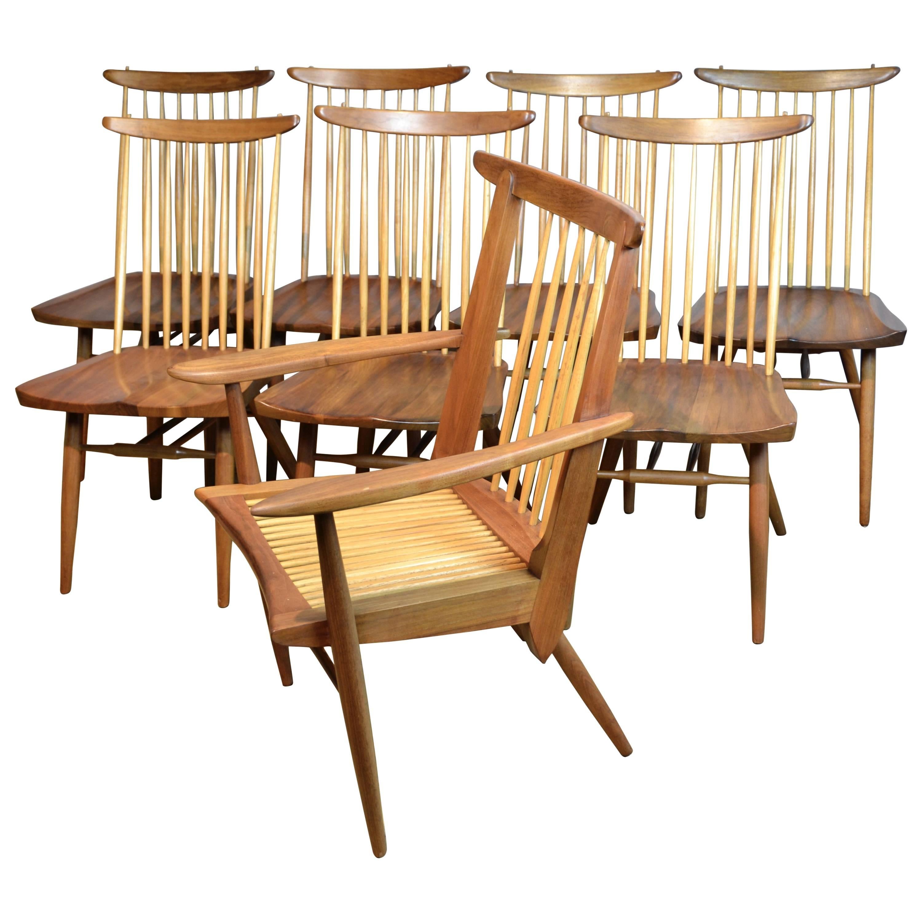 A suite of eight walnut dining chairs by George Nakashima. The chairs date from 1963 and are excellent examples of his studio furniture with hand shaved hickory spindles, hand planed walnut plank seats, turned legs, and hand shaped crest rails. The