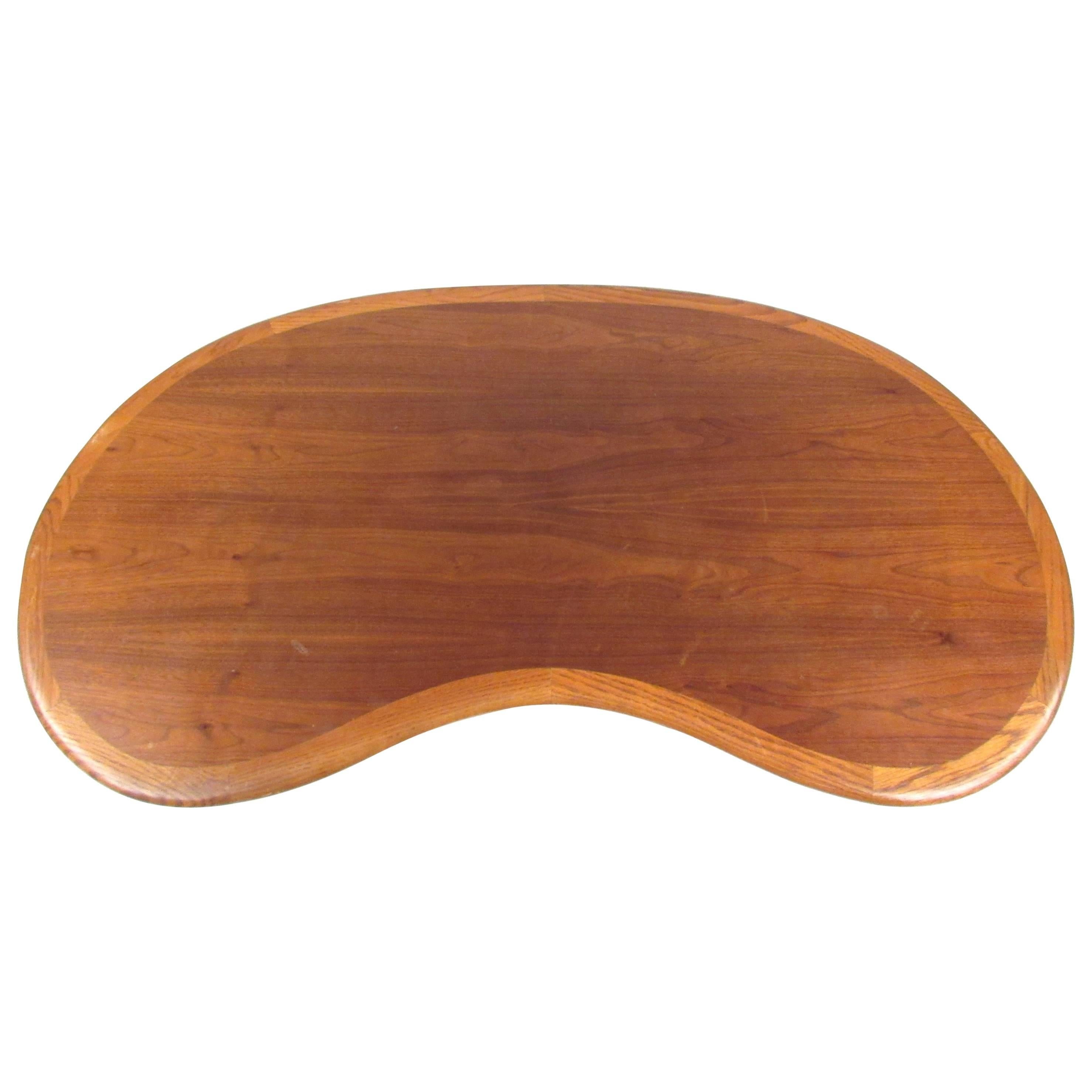 Classic kidney-shaped walnut coffee table by Lane featuring x-shaped base and banded lighter oak trim at the perimeter.