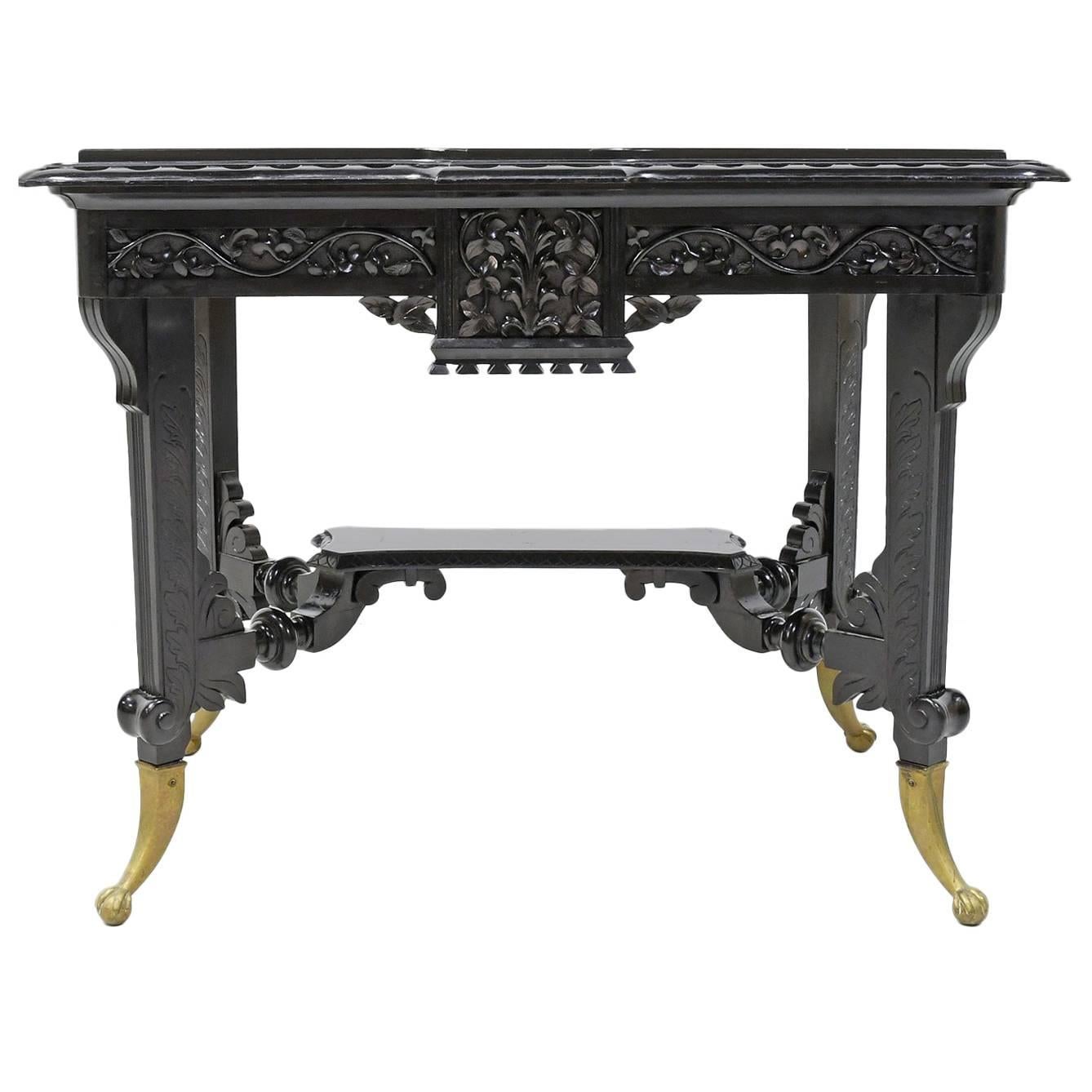 Aesthetic Movement Centre Table in Carved Ebonized Wood with Brass Feet, c. 1870