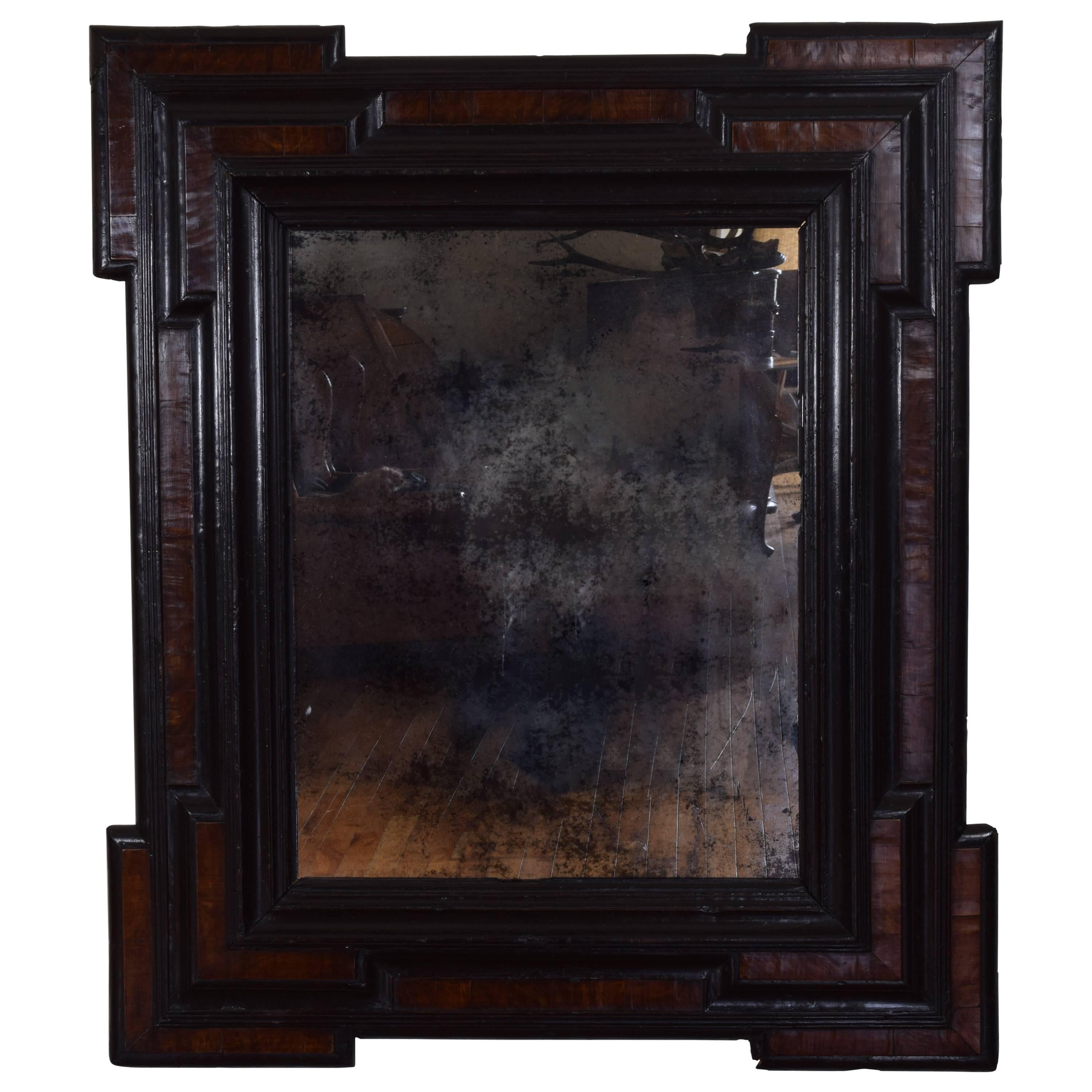 The frame having notched corners and raised moldings, walnut veneers and ebonized moldings, now fitted with an 