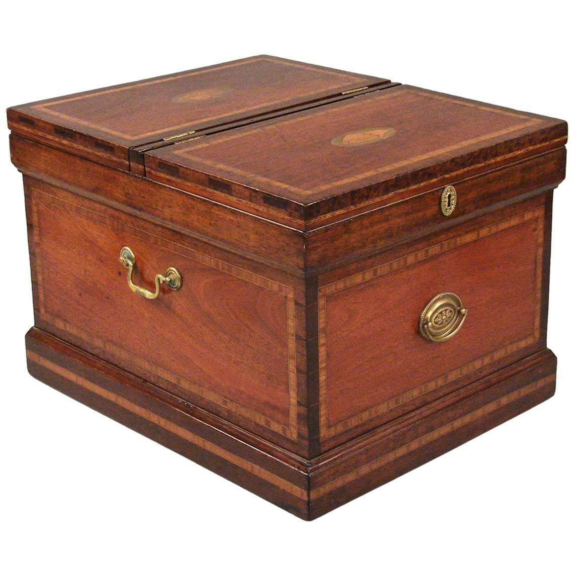 A Hepplewhite style inlaid mahogany cellarette, the two-part top with satinwood banding and inlaid conch shell decoration, one side opening to a fitted interior, the four banded sides centered with later brass hardware and inlaid conch shells,
