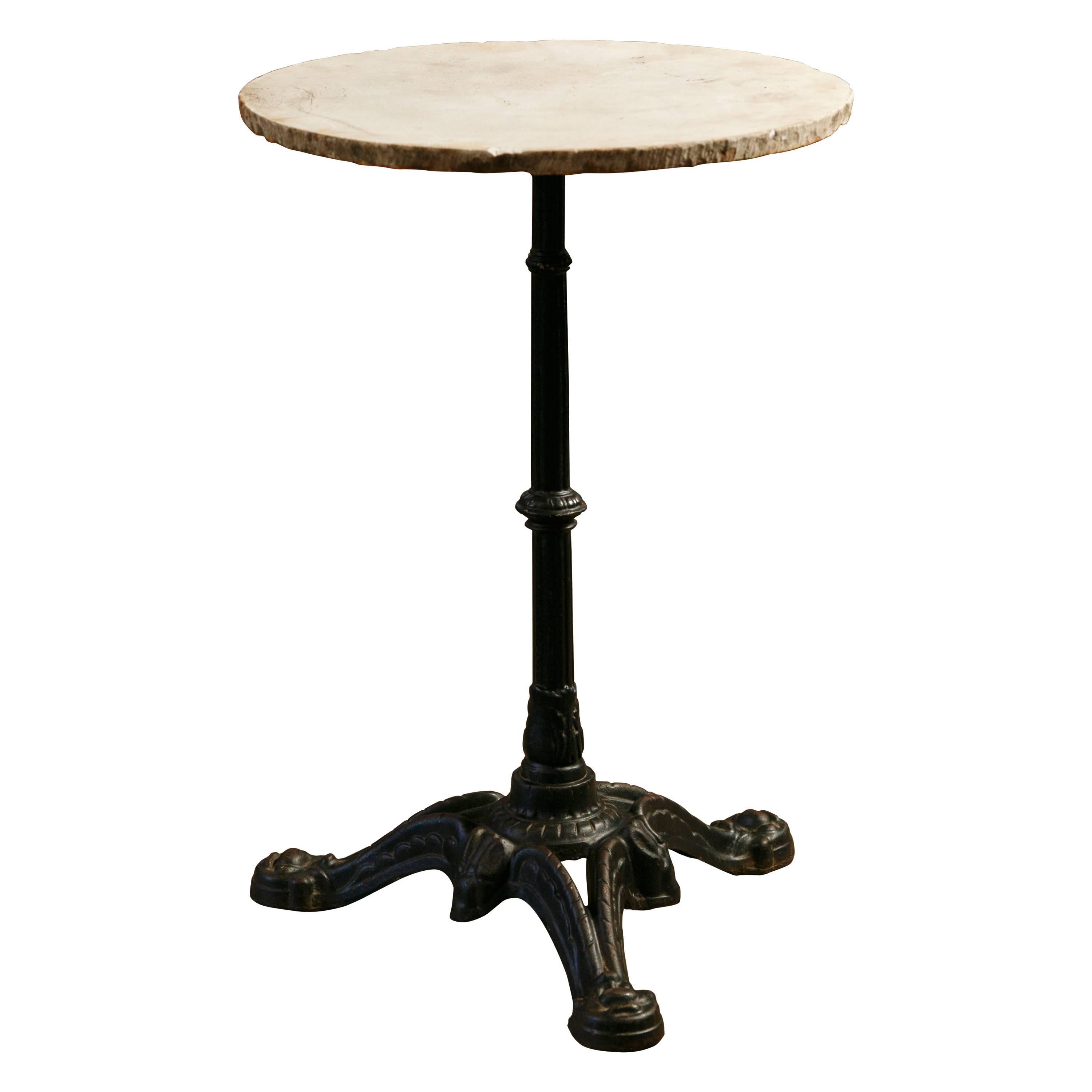 Pair of French bistro or garden tables with antique painted cast iron bases (circa 1900) and vintage white with grey veined marble tops (circa 1960). Bases have stylized paw feet.