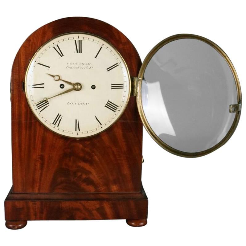Antique English Regency Frodsham bracket clock features footed arch-top mahogany case with bronze mounts, pierced brass side frets, fusee movement, anchor escapement and "Frodsham Gracechurch Street London" stamped on back, and mahogany