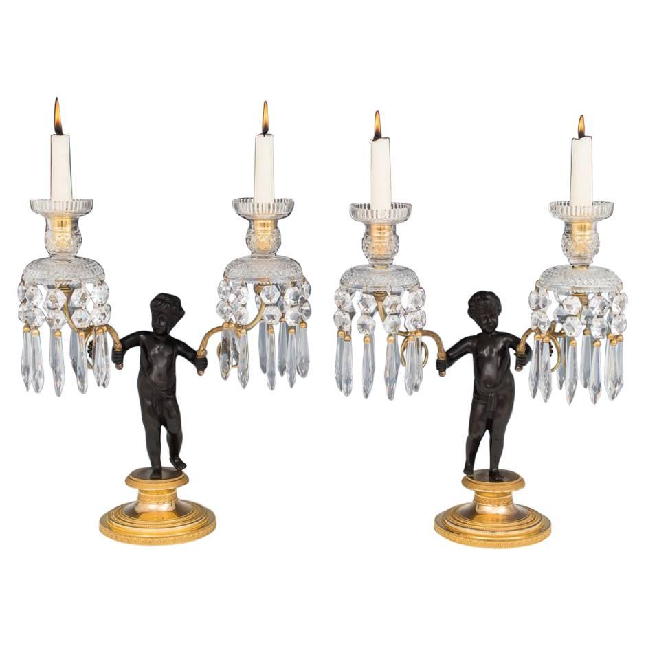 Exceptionnelle paire de candélabres en bronze doré représentant des chérubins de la période Régence