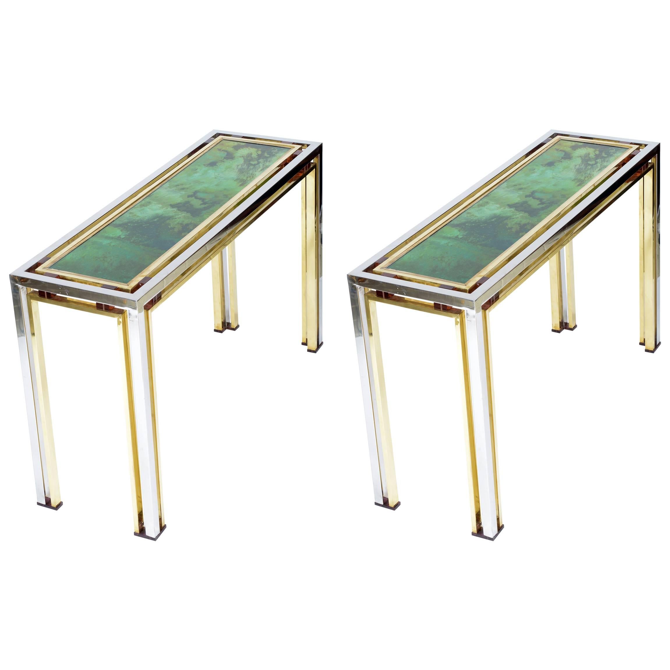 Chromed and brass structure with amber color Lucite details on the up corner and feet.
The top is a painted glass and after covered with gold leaf that create an abstract decoration.
This consoles are finished in all the side and can be put in the