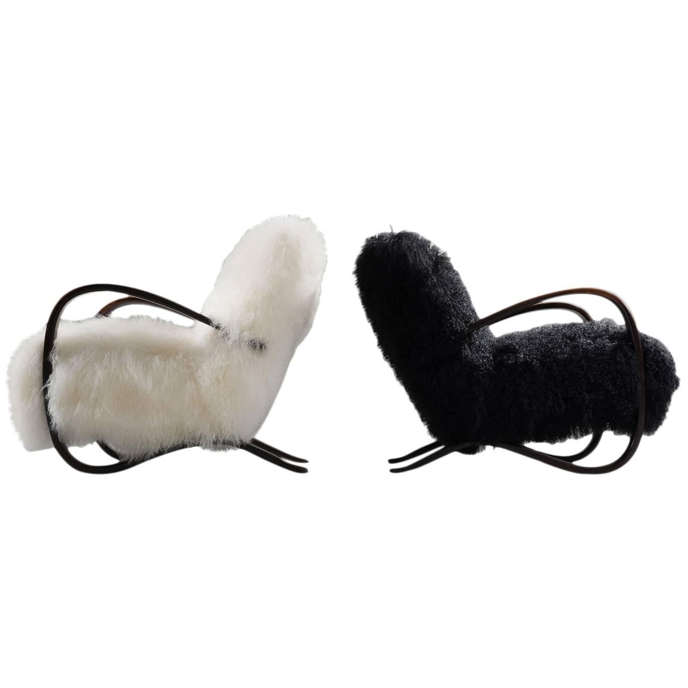 Pair of lounge chairs, in beech and sheepskin, by Jindrich Halabala (1903-1978), Czech Republic, 1930s. 

Extraordinary pair of black an white easy chairs with Tibetan lambswool upholstery. These chairs have a very dynamic and abundant appearance.
