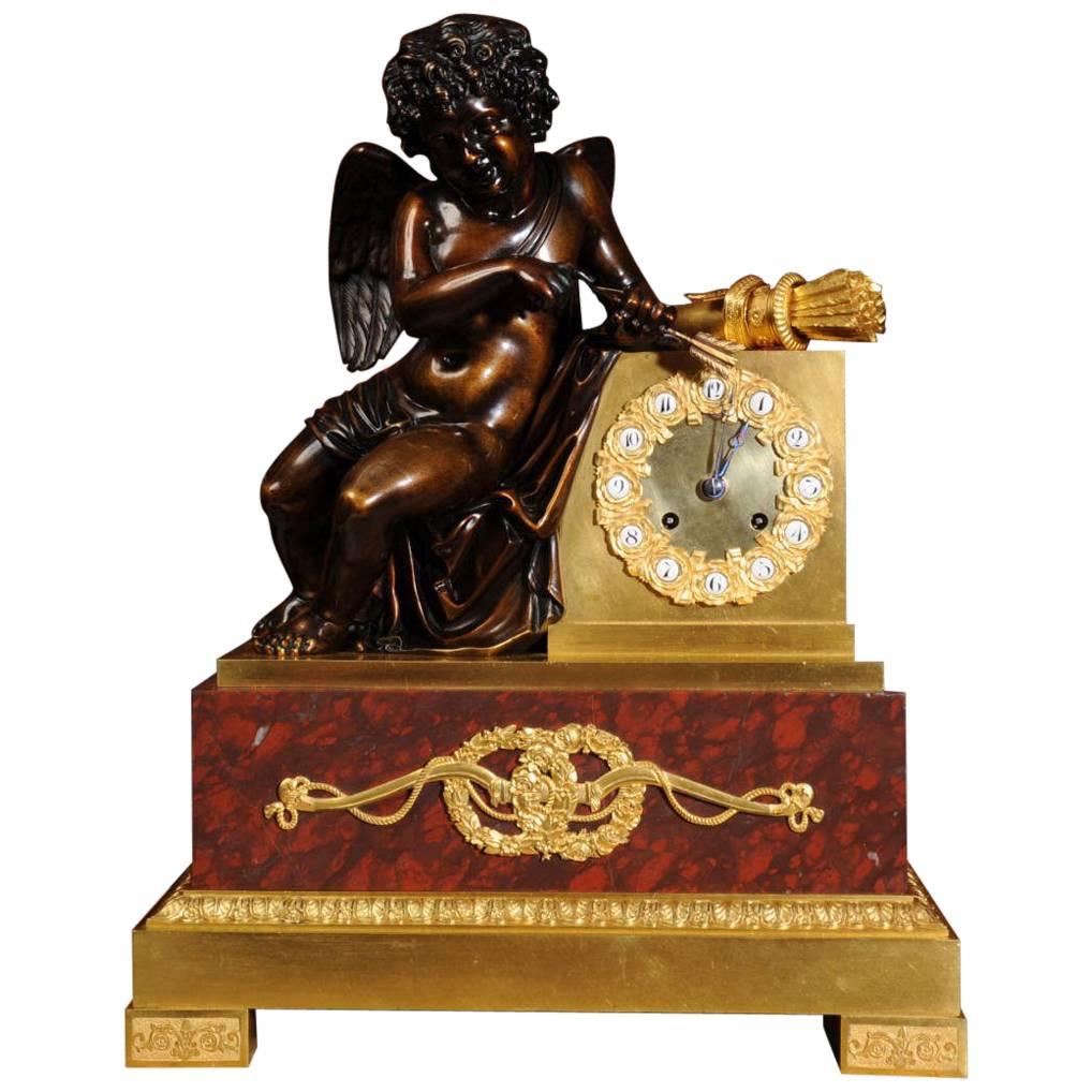Horloge ancienne et raffinée en bronze, bronze doré et marbre spécimen avec Cupidon