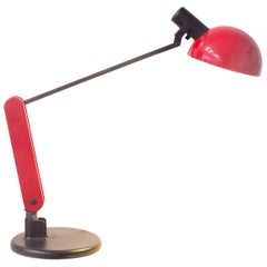 Circa 1970, lampada da scrivania Guzzini rossa e nera con base pesante