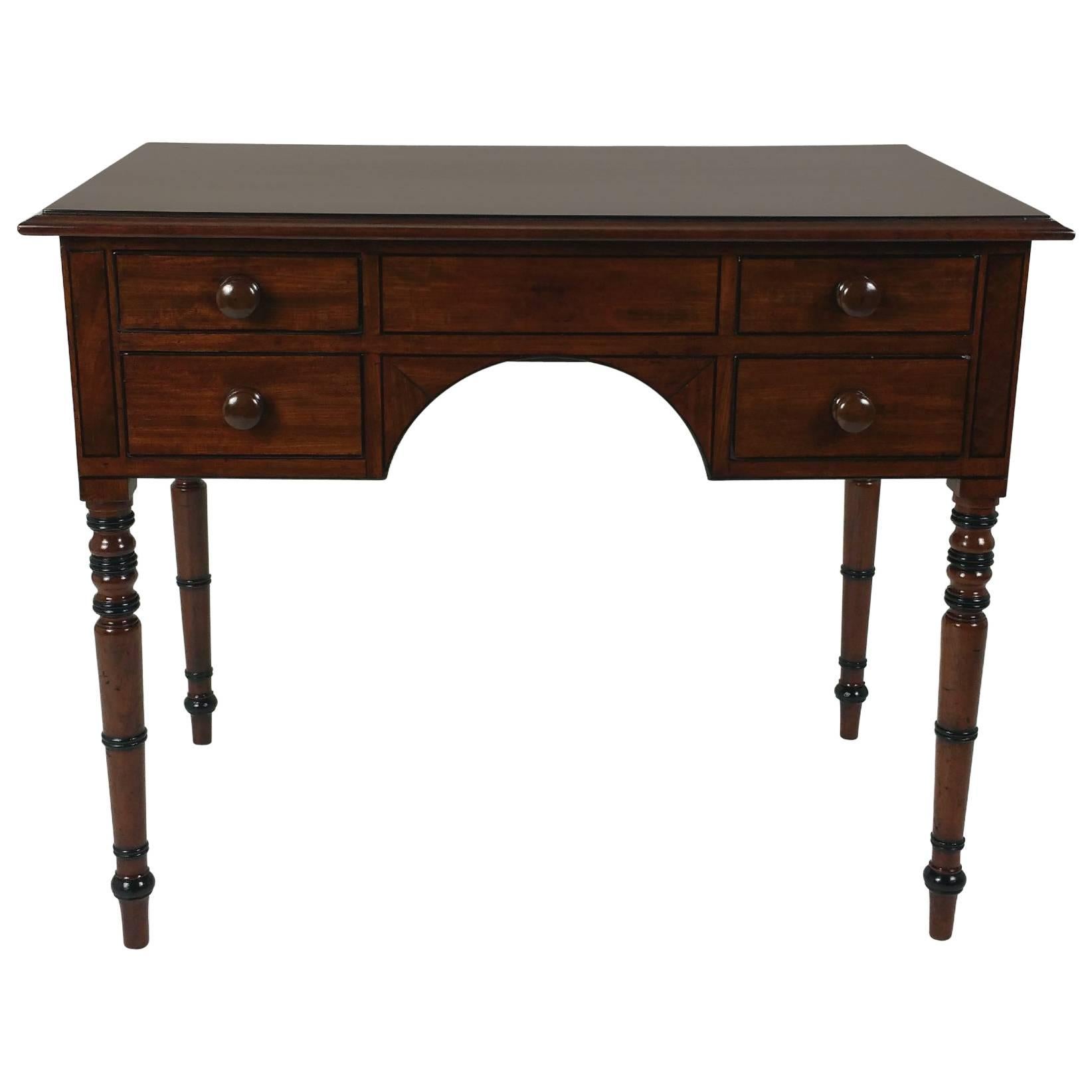 This beautiful Regency mahogany kneehole side table features four drawers with ebony line inlay, and stands on turned supports. It measures 44 in – 111.7 cm wide, 26 in – 66 cm deep and 30 in – 76.2 cm high.