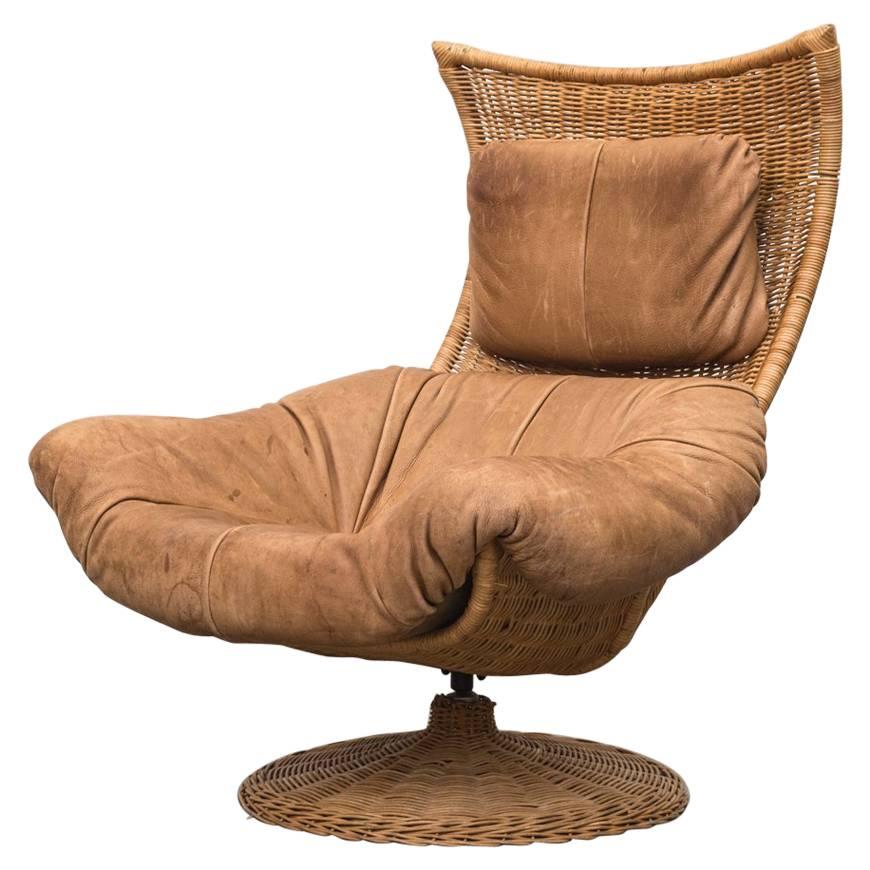 Original rattan lounge chair with new leather cushion. Gerard Van Den Berg arguably defined a turning point from Classic Mid-Century Dutch furniture design to more contemporary design using different materials, such as rattan and leather. For