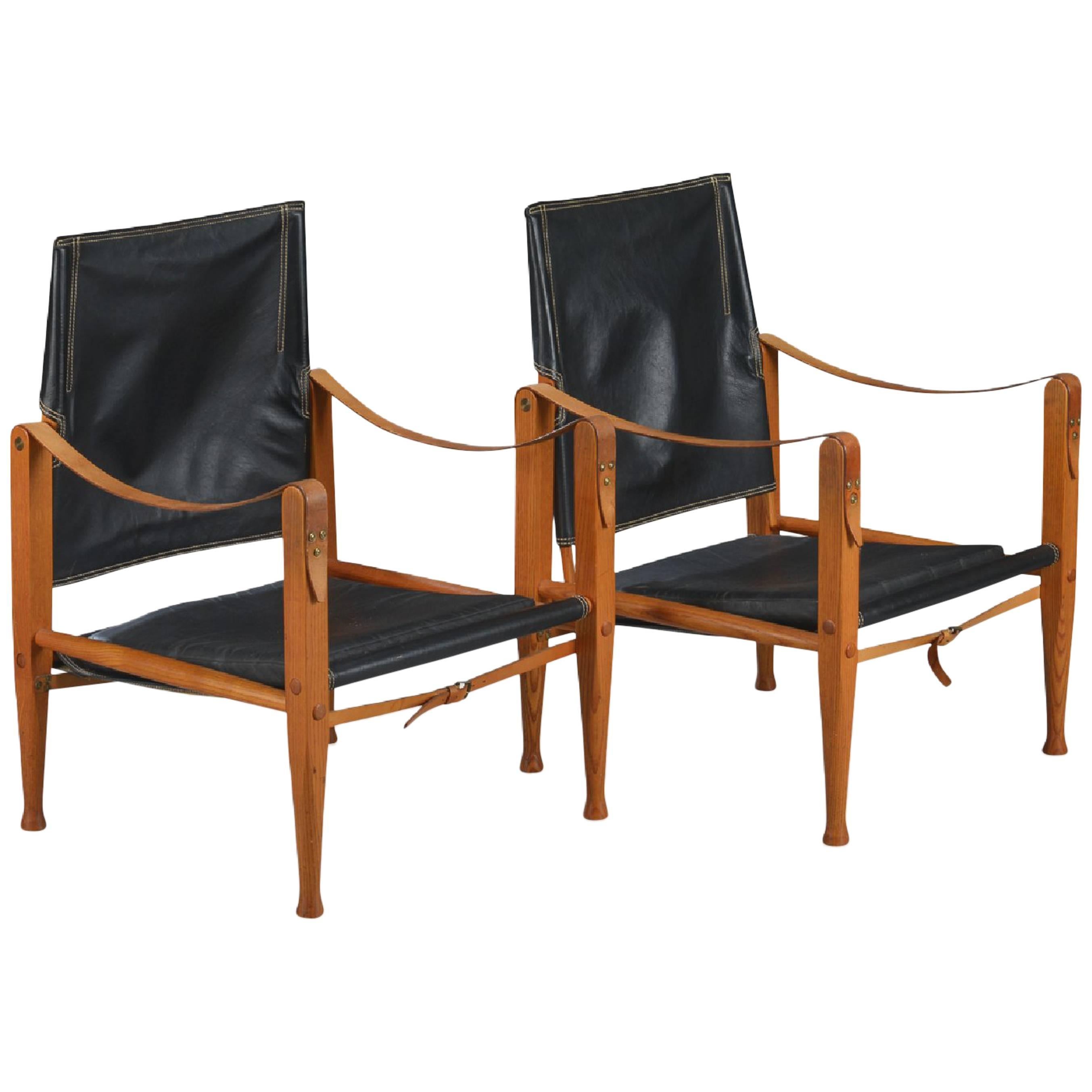 A pair of Kaare Klint Safari chairs, made by Rud Rasmussen, Denmark. Black leather and ashwood.