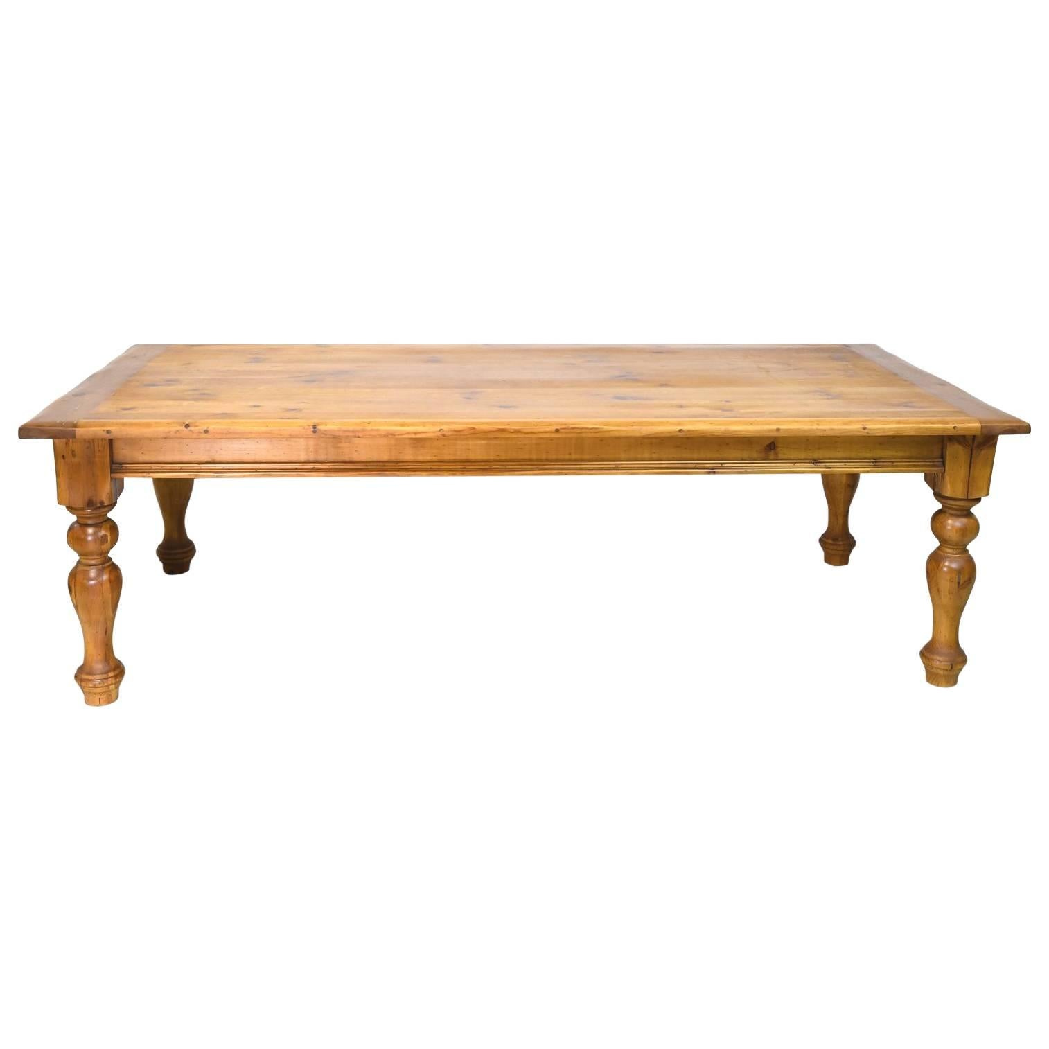 A long European style farmhouse dining table in pine with plank-top and handsome turned legs. Beautifully finished in a natural hand-rubbed oil finish. England, circa 1990s.
Note: Top has two coats of an organic LEED certified catalyzed oil finish