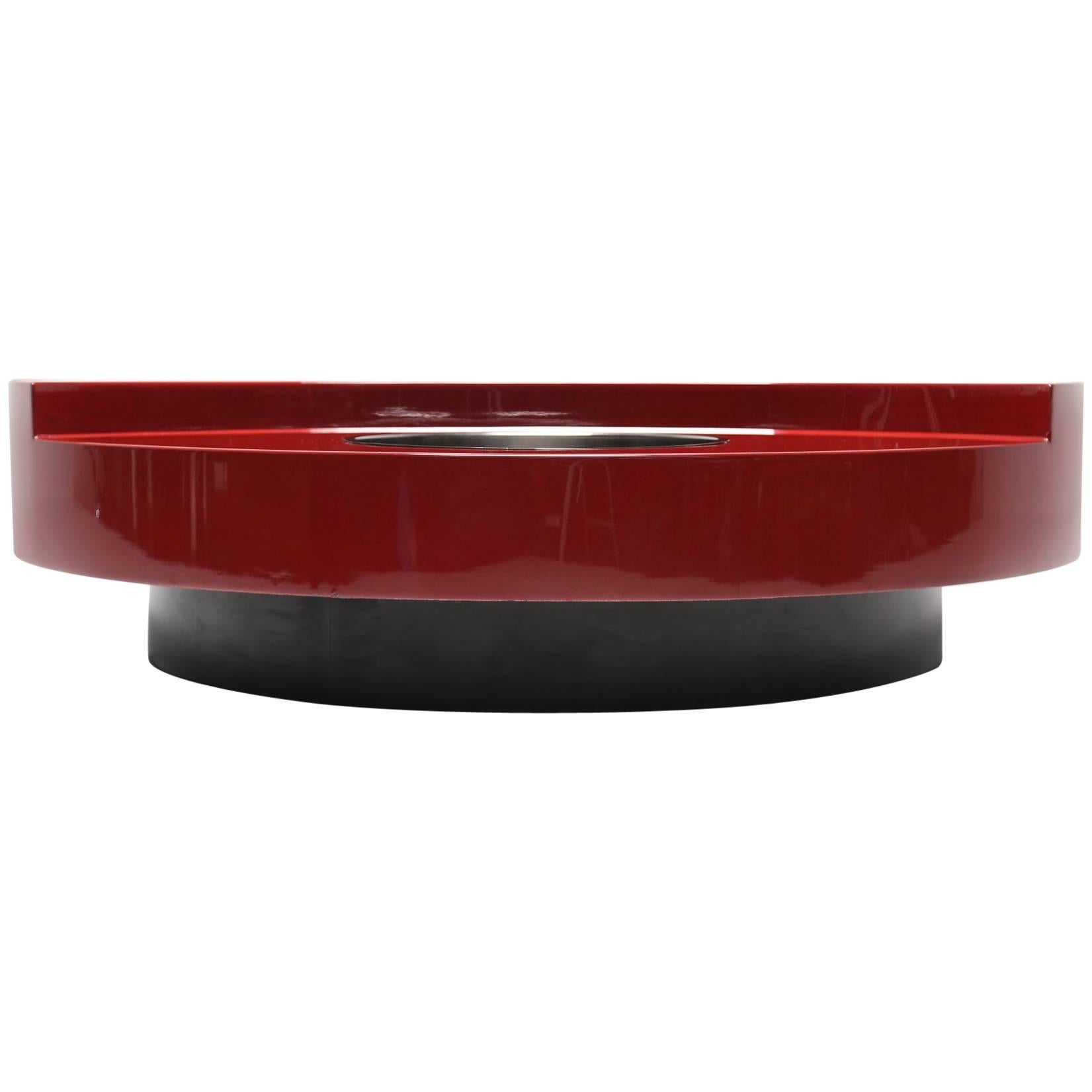 This super glam TRG revolving cocktail/coffee table is the epitome of rock n' roll. Designed by celebrity photographer Willy Rizzo in the 1970s this red oxblood lacquered table with subtle black flecks revolves on a black plinth. A chrome drinks