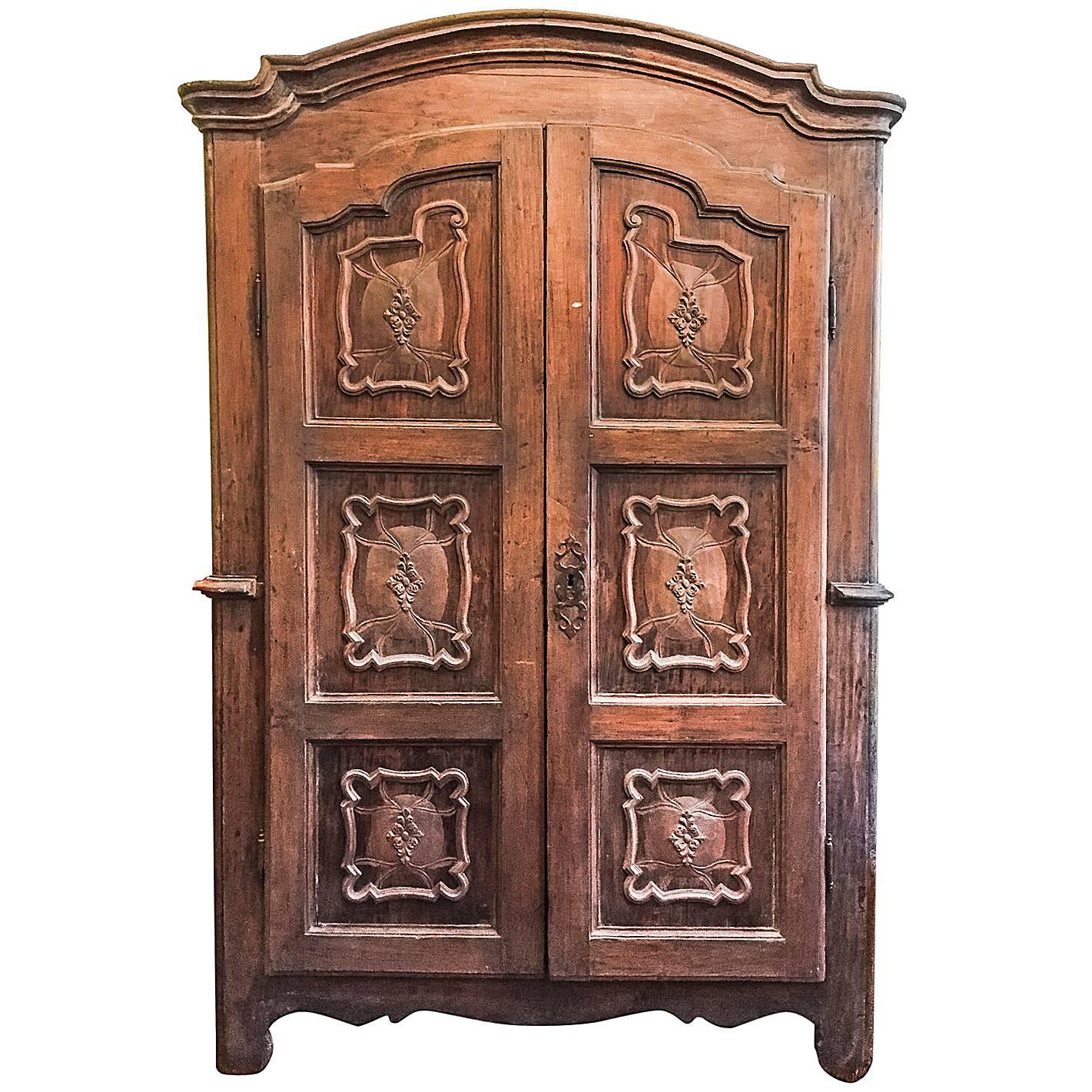 This antique two-door carved armoire was made in Italy, in Piedmont, from solid poplar, dating back to late 18th century and coming from a private villa of Milan. 
Features a thick stepped and curved crown molding and an elegant original solid wood