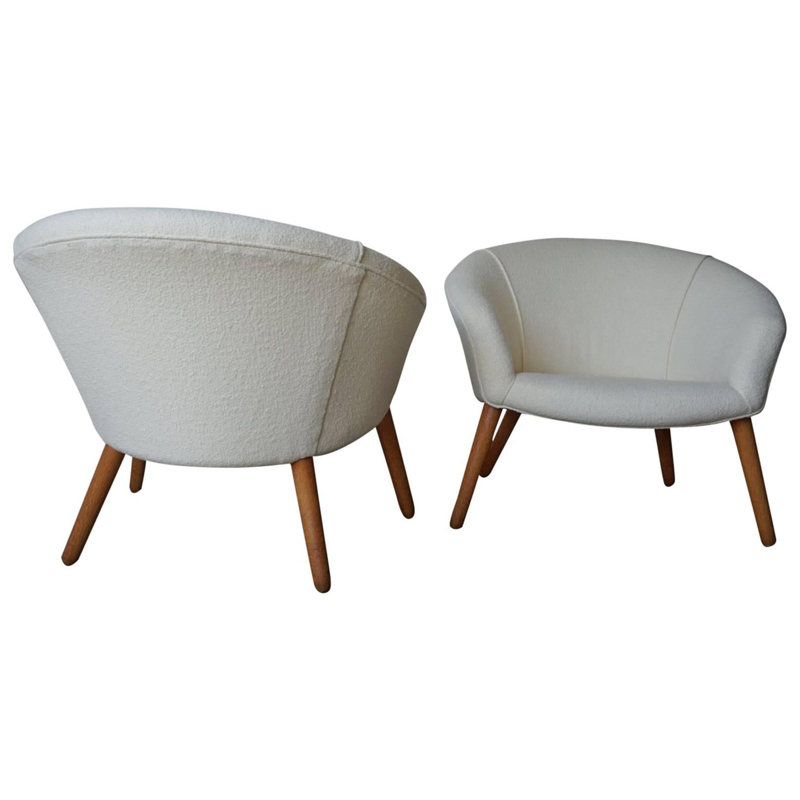 Stunning pair of model AP 26 “Pot Chairs” by Nanna Ditzel, and produced by AP Stolen, circa 1953. Recently restored in a beautiful pearl-colored Knoll bouclé fabric. Tapered oak legs.
