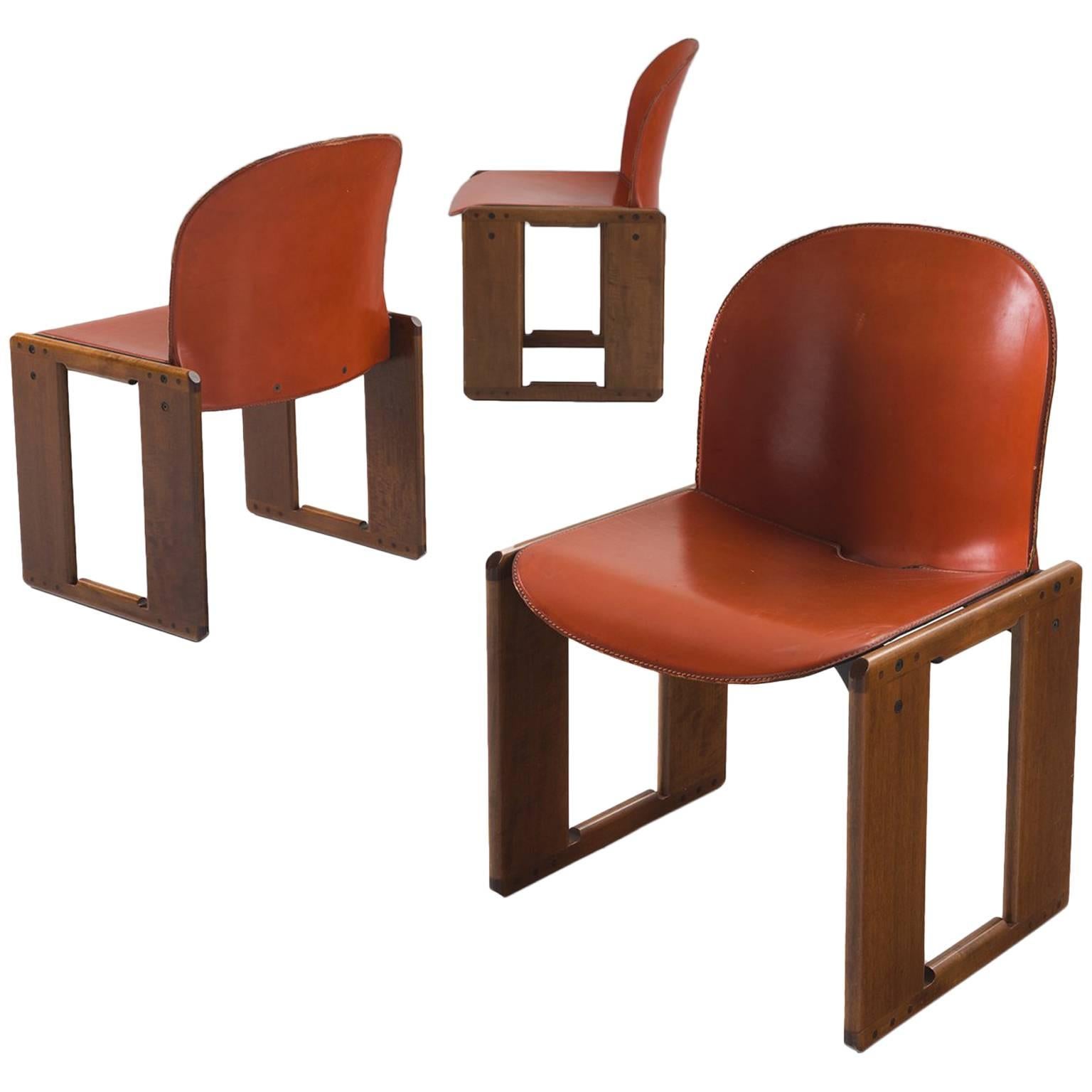 Dining chair by Afra and Tobia Scarpa for B&B Italia, Italy, 1974.

This set of six dining chairs is both slender and firm at the same time. The leather seat and back very thin but strong thanks to the wood that is used to strengthen the chair.