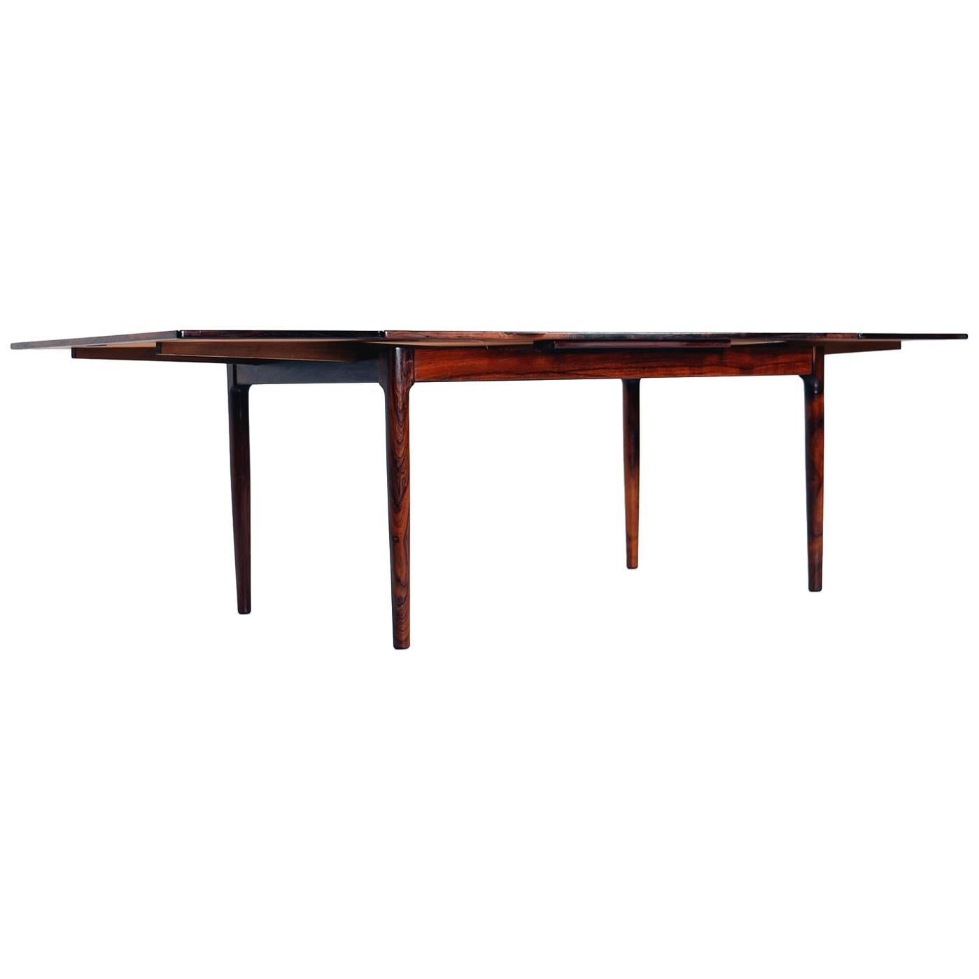 Gorgeous Scandinavian modern rosewood extendable draw leaf dining table, made by Bernhard Pedersen & Sons of Denmark, 1970s. Beautifully aged rosewood with a rich patina and gorgeous grain, quality craftsmanship and exquisite design. Fully