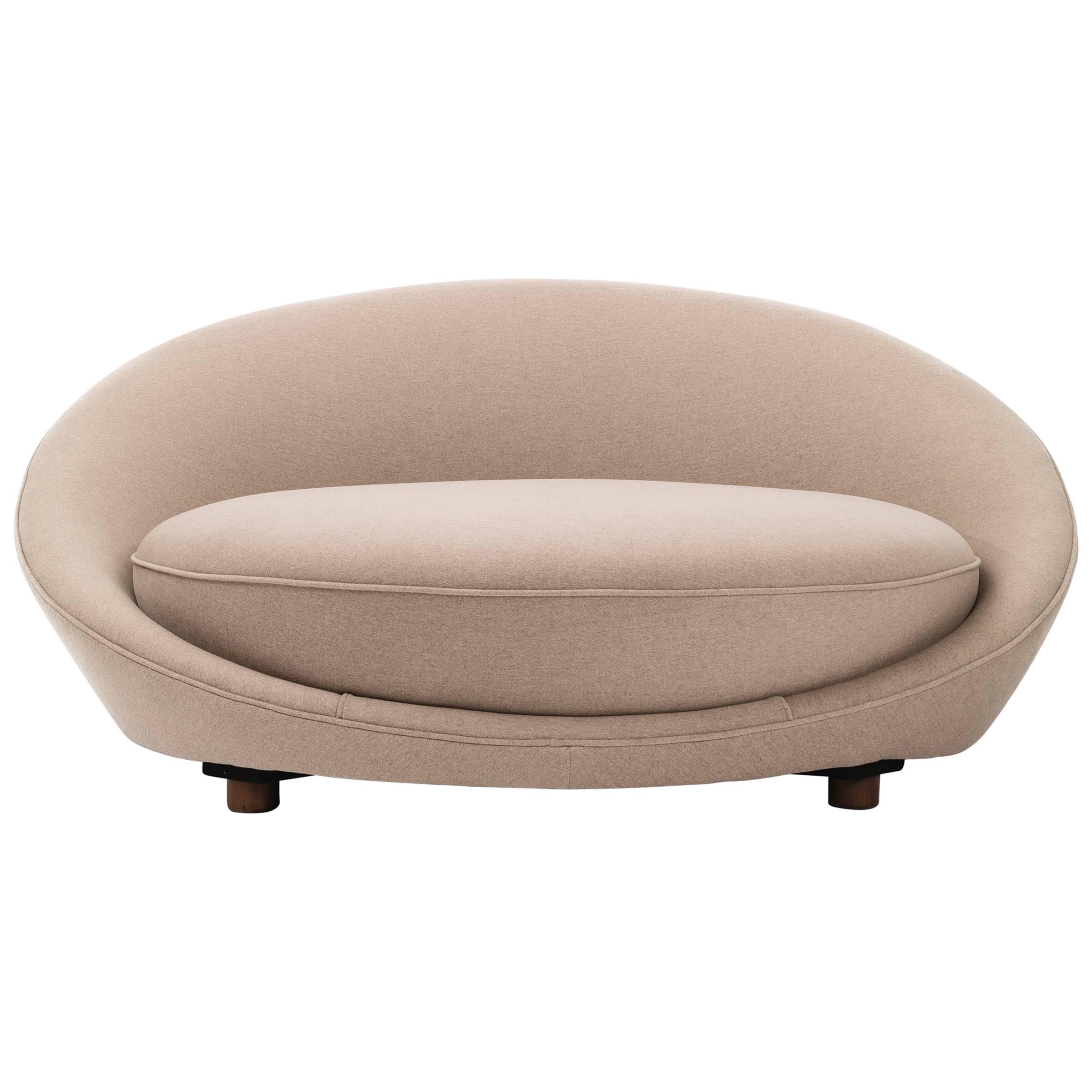 Oversized chaise longue for 1-2 people. Newly upholstered with foam and fabric. Curved barrel back with spring cushion on four wooden legs.