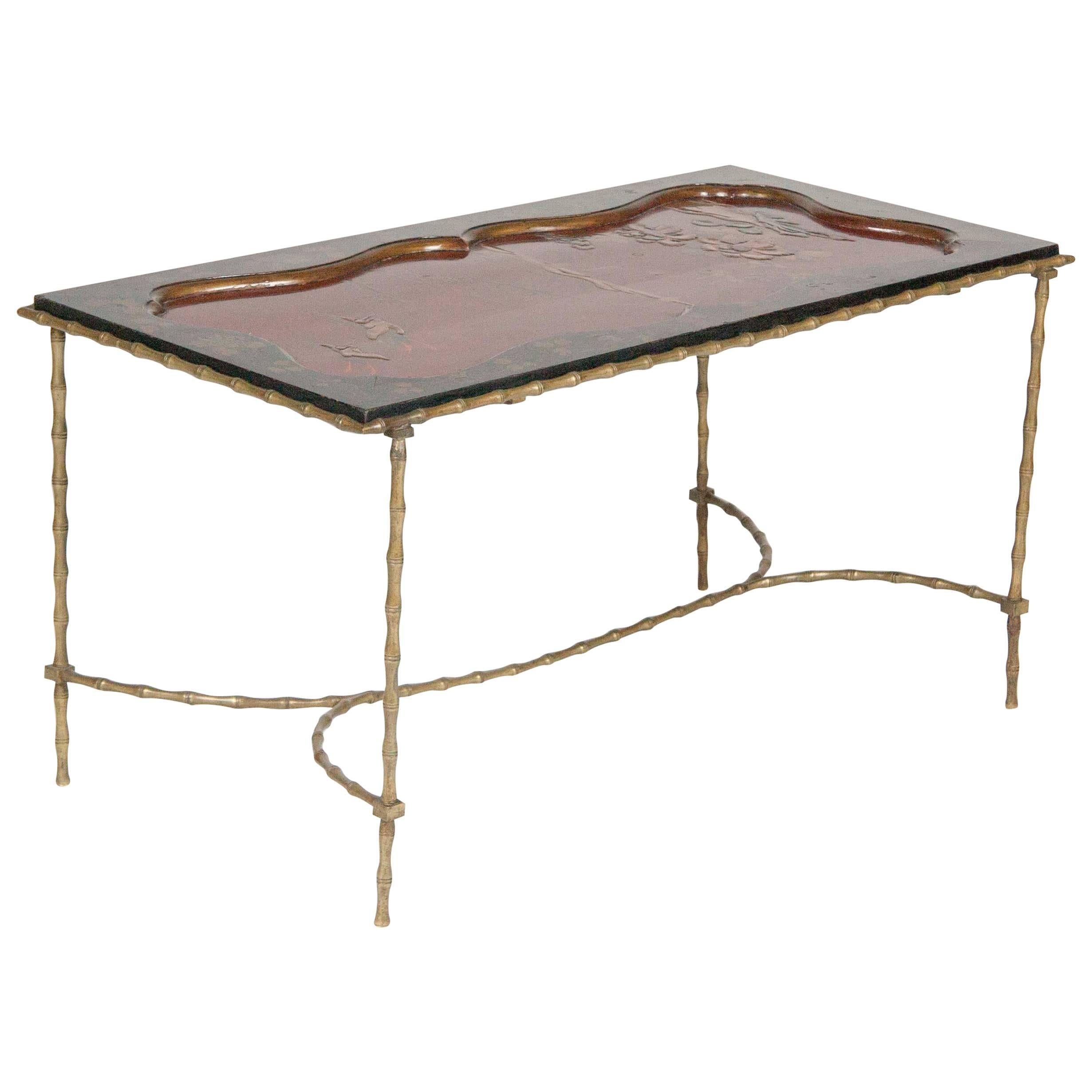 A cocktail table having a Japanese lacquered top set upon a Bagues brass, faux bamboo base. 

Top from 19th century 
Base circa 1950.