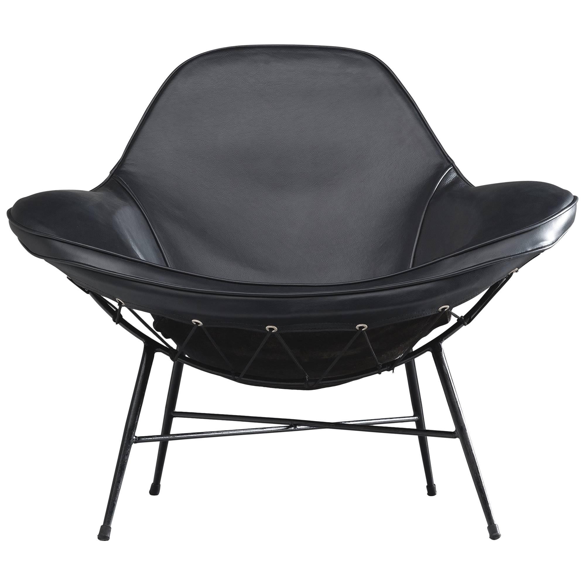 Armchair, iron, upholstery, cushion and leather, 1950.

This wide inviting armchair with thin black iron frame is designed by Martin Eisler. The seat of the chair is inviting, organic and comfortable. This shape is very iconic for the designs by
