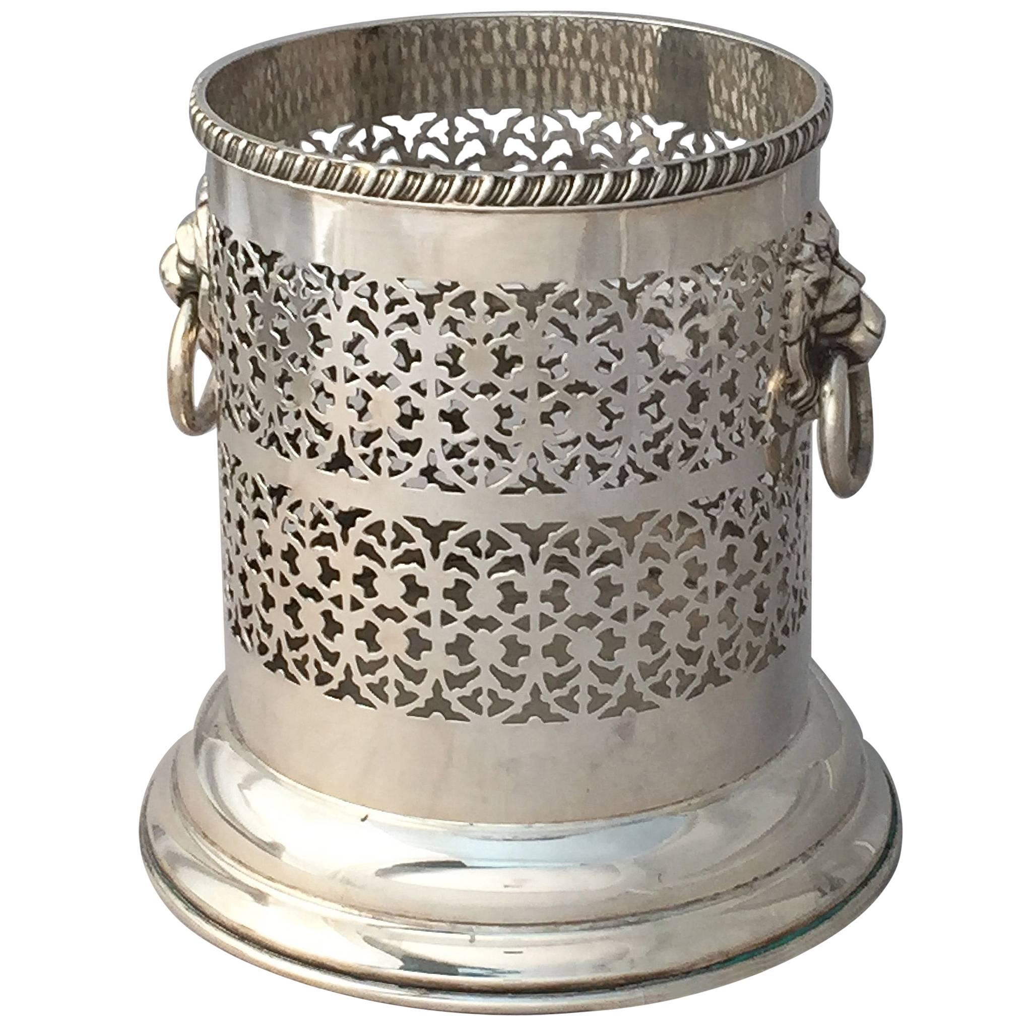 A fine English wine bottle display holder or coaster of plate silver, featuring a pierced design around the circumference and opposing Regency lion ring pull handles, with rolled edge around the top.

Designed to add a fine level of elegance to