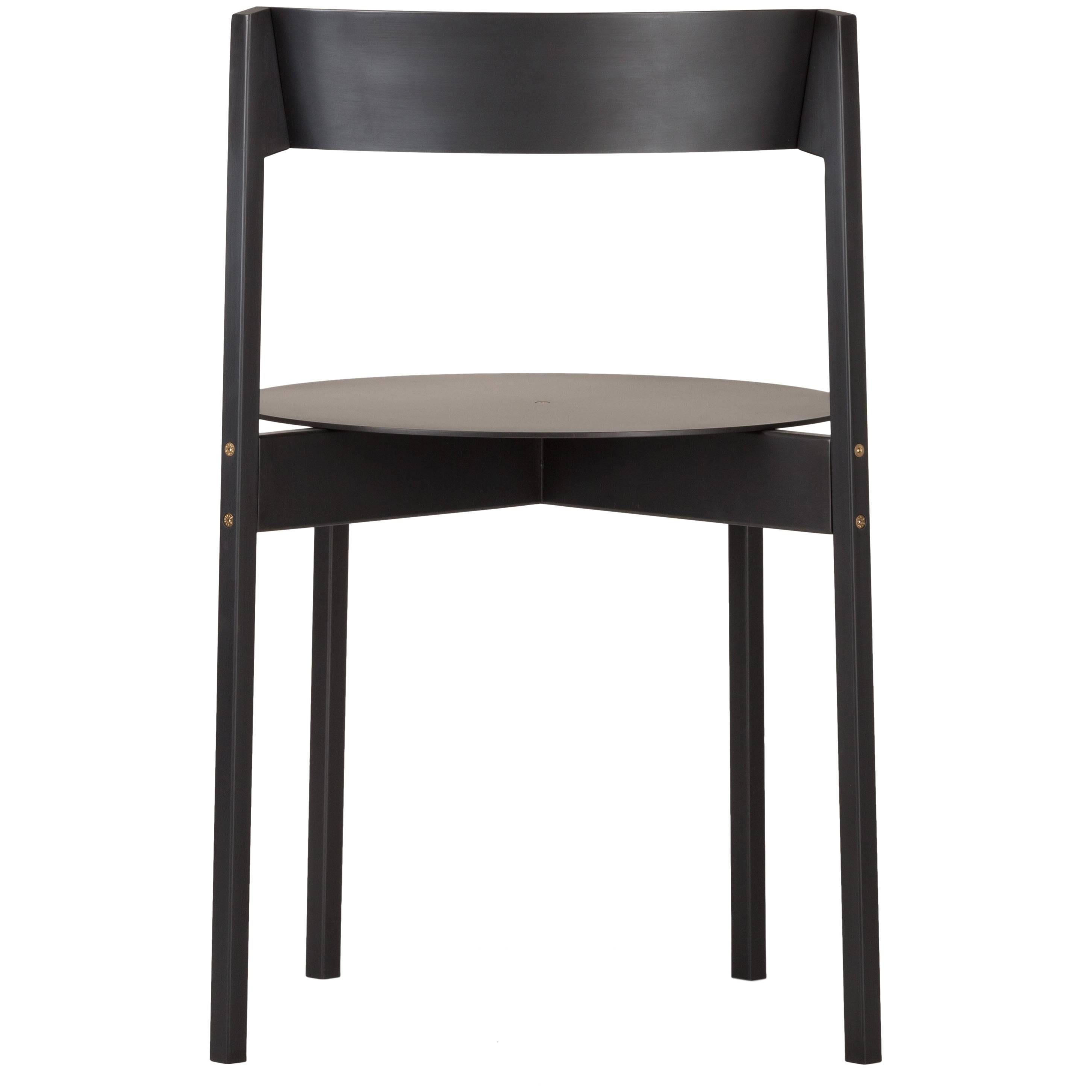 Chaise modulaire empilable en fer caractérisée par des lignes épurées et fondamentales, et une esthétique authentique enrichie par des vis hexagonales à tête fraisée en laiton. 

La chaise est composée de seulement sept éléments qui peuvent être