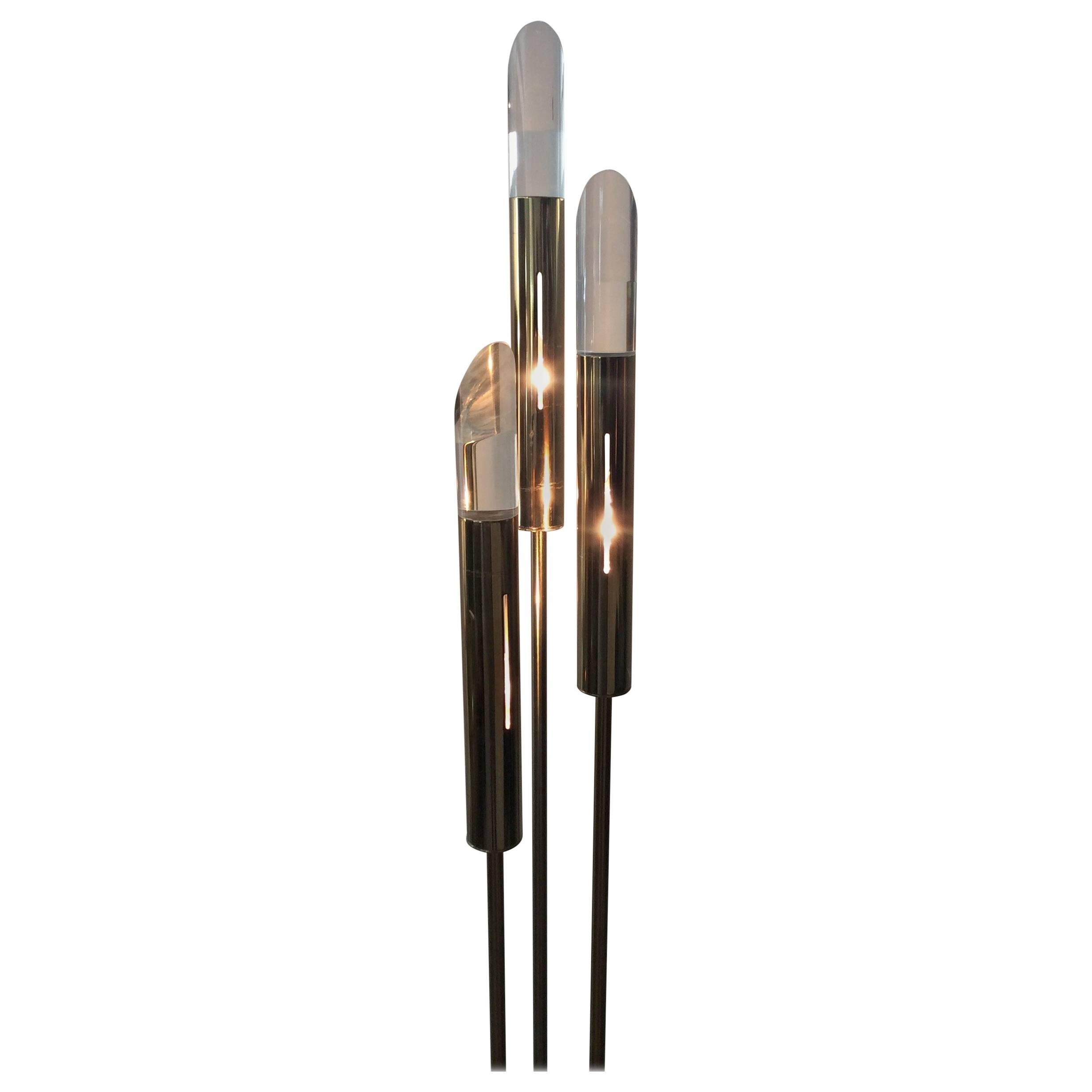 Your looking at this modern brass and Lucite floor lamp very much in the style of Hollis Jones. The base plate is a round metal disc plated in brass fin. The 3 staggering height center metal rods are also plated in brass. The bulb housing sleeve