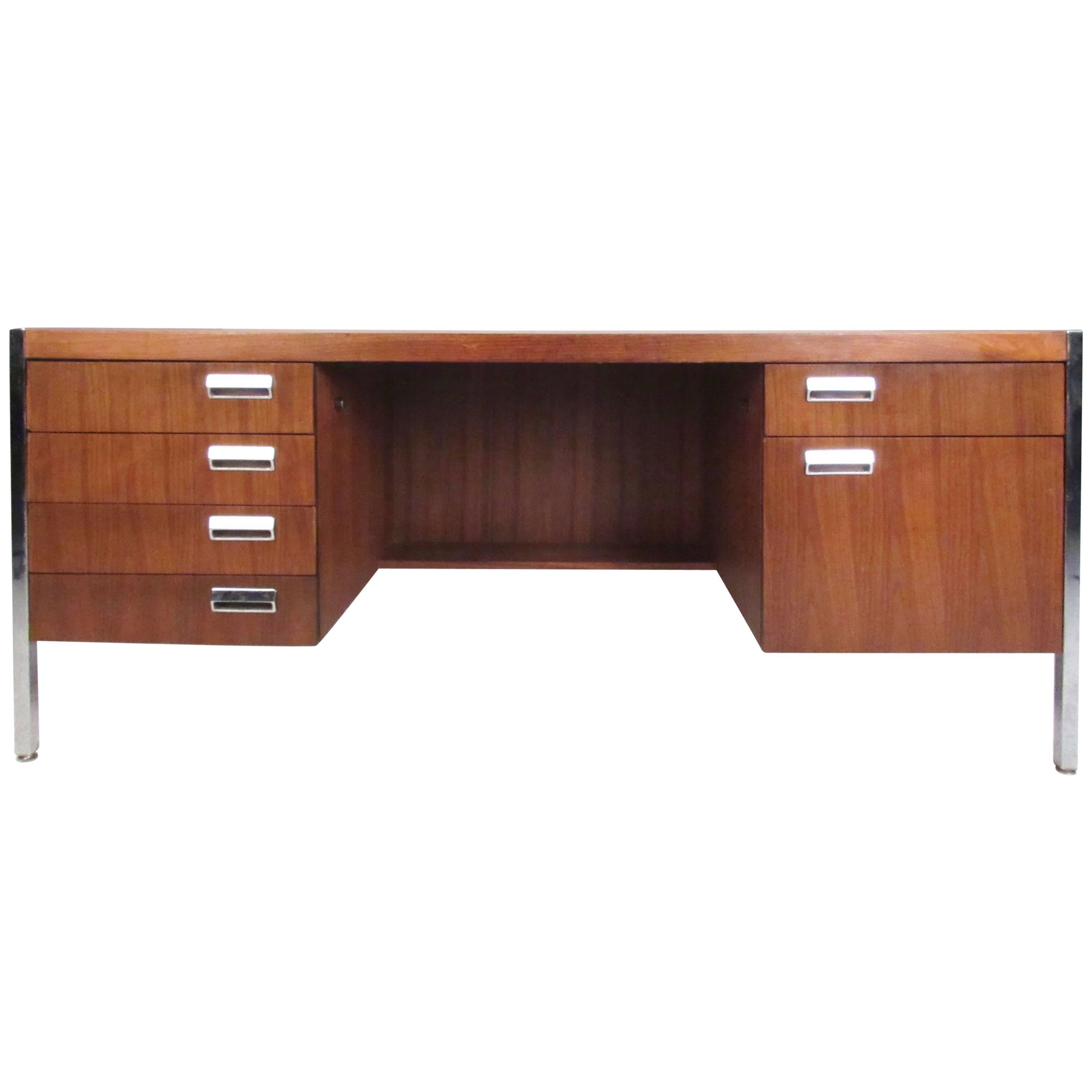 This stylish vintage desk features six drawers for storage, striking vintage walnut finish and Milo Baughman style chrome legs and handles. Finished cut-away back makes this a beautiful addition to any home or business office. Please confirm item
