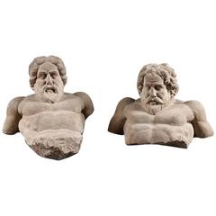 A pair of Herculean carved reclining stone men