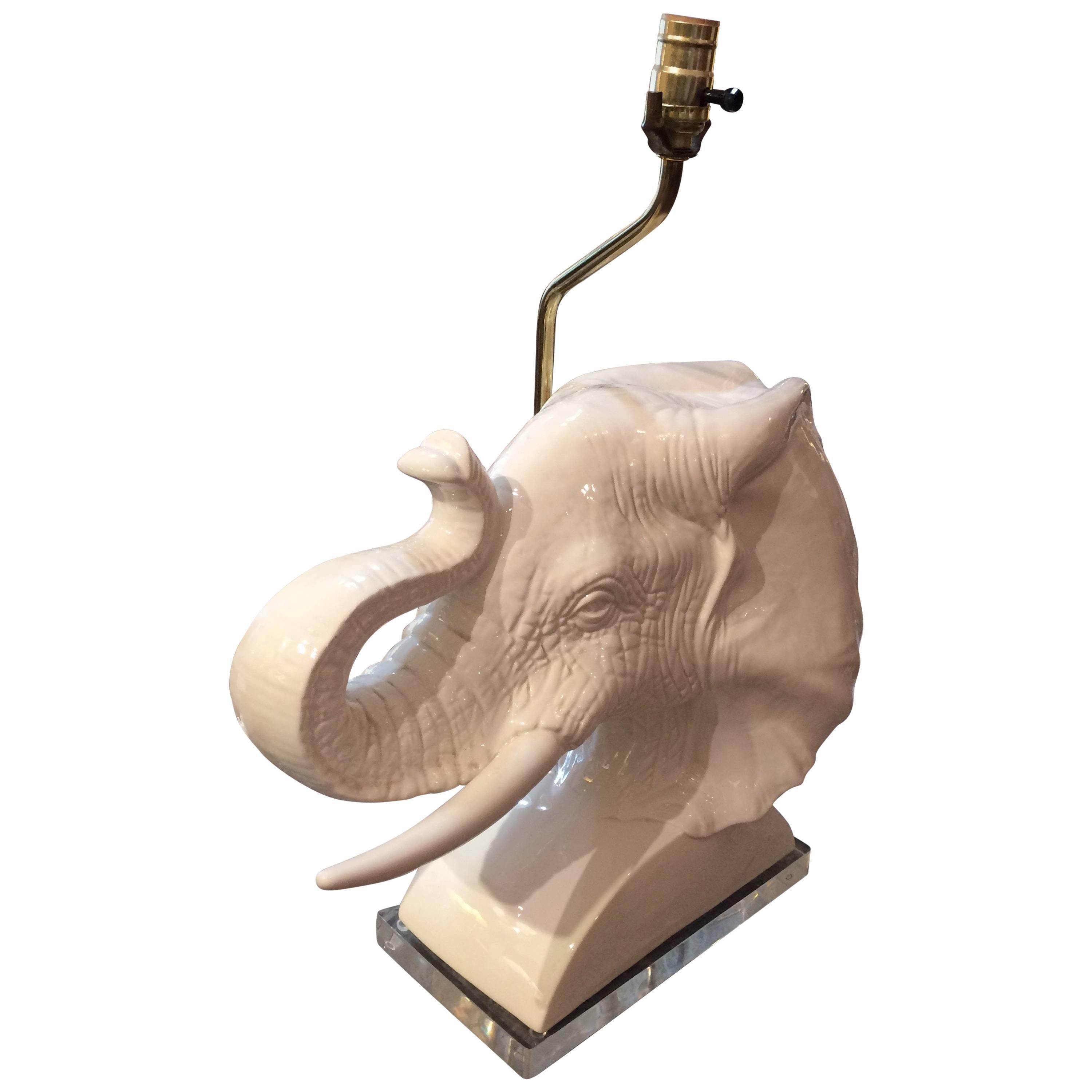 Two dramatic white ceramic table lamps in the shape of an elephant bust, sitting on a cool piece of Lucite. No shade included. 24 in H to top of socket
60 watts.