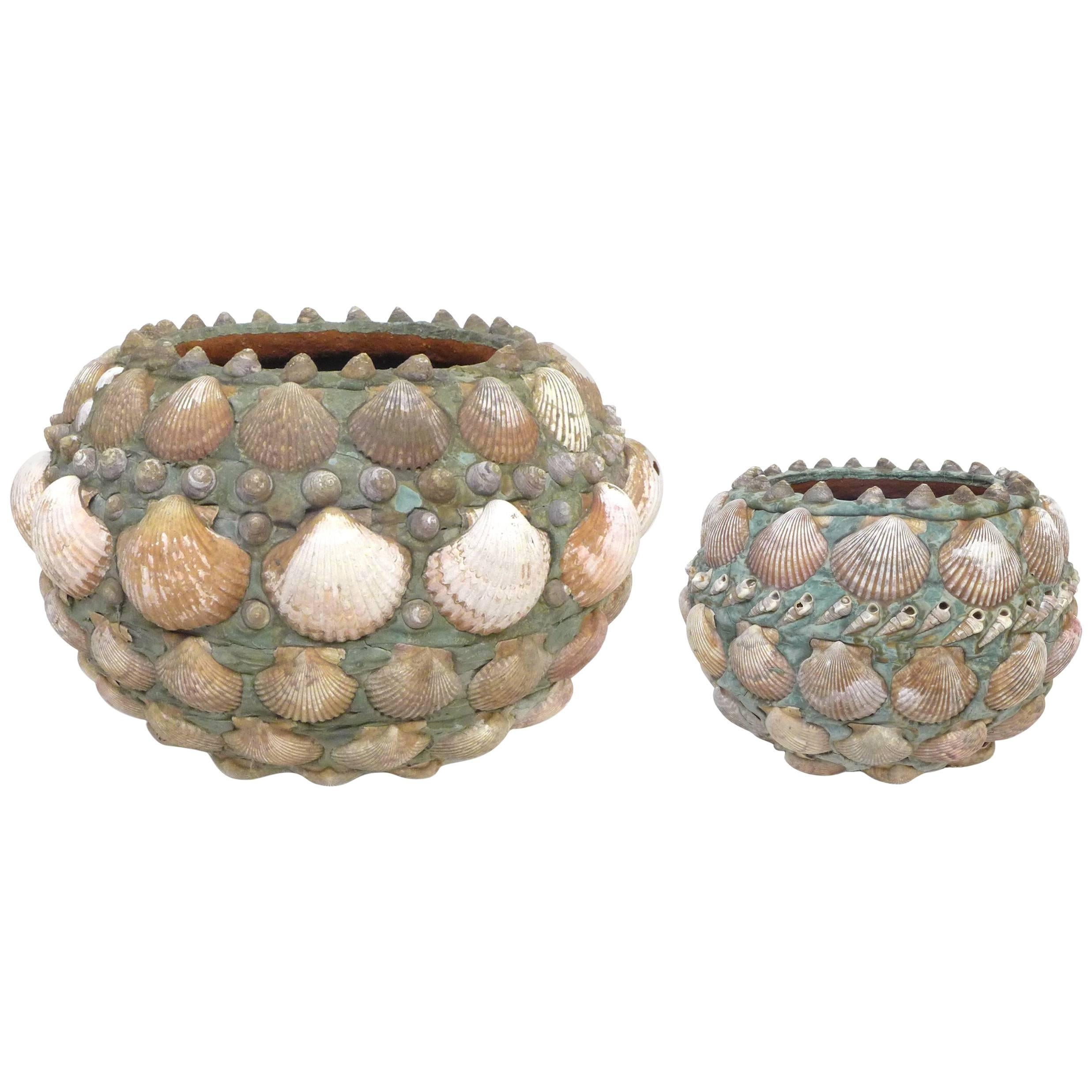 A fantastic, seashell-encrusted terra cotta planter.  An eye-catching, likely Folk Art vessel fully and thoughtfully clad (including underneath) in various shells applied atop an aquamarine substrate.  Fantastic patina from life outdoors.  A fun and