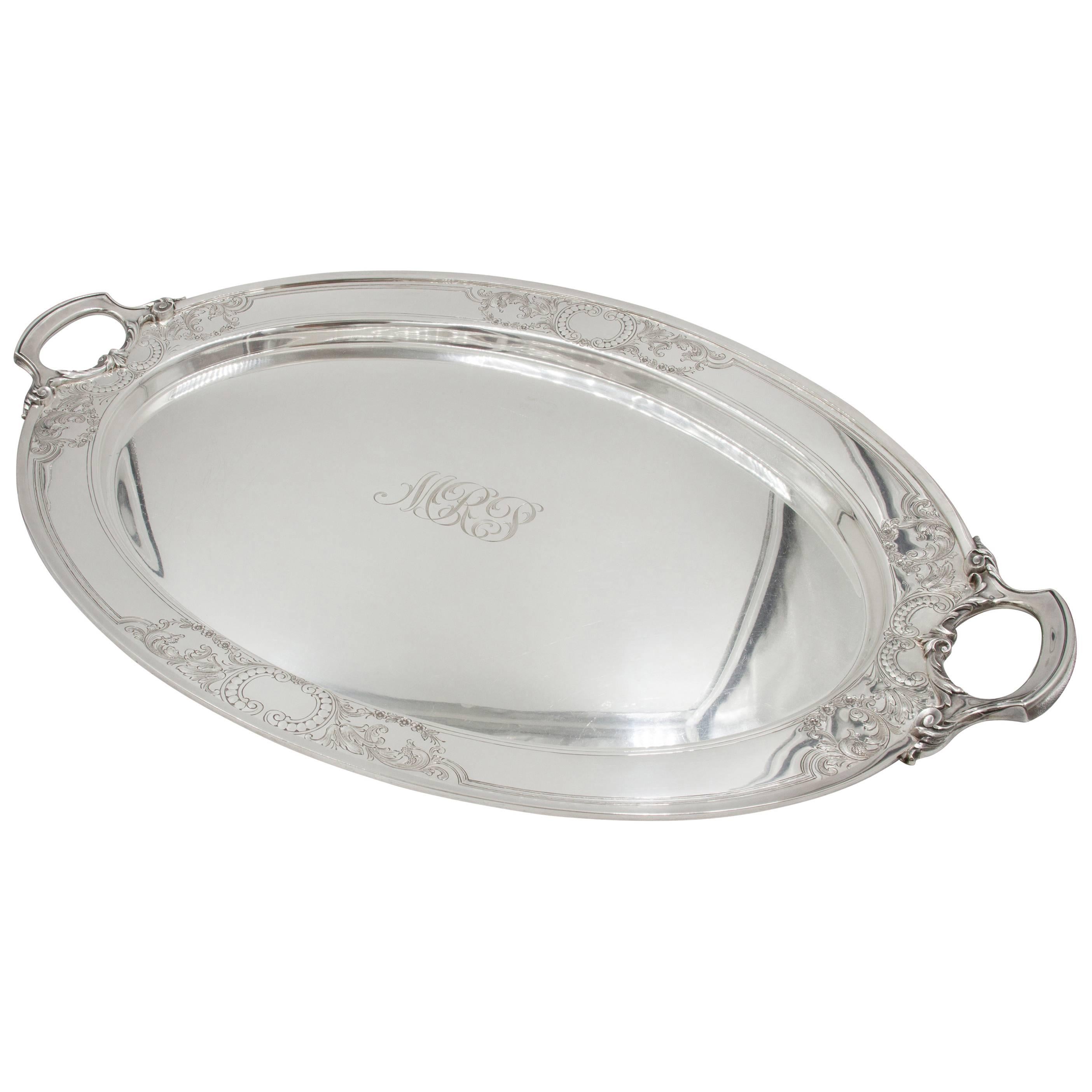 This oval serving tray would be ideal under a large tea set or for those grand dinner parties or a large get-together. Crisp etchings of garlands and flowers are found around the handle and again along the center border (2.5). In the center there's