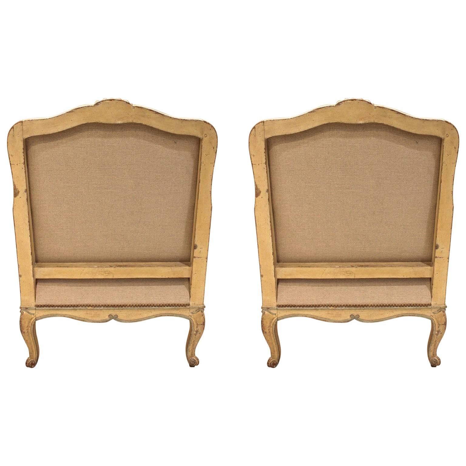 Pair of antique French early 19th century Louis XV bergeres, with detailed carvings, curved legs, curved top and skirt, and French paint, completely taken down and reupholstered with French linen in Provence.