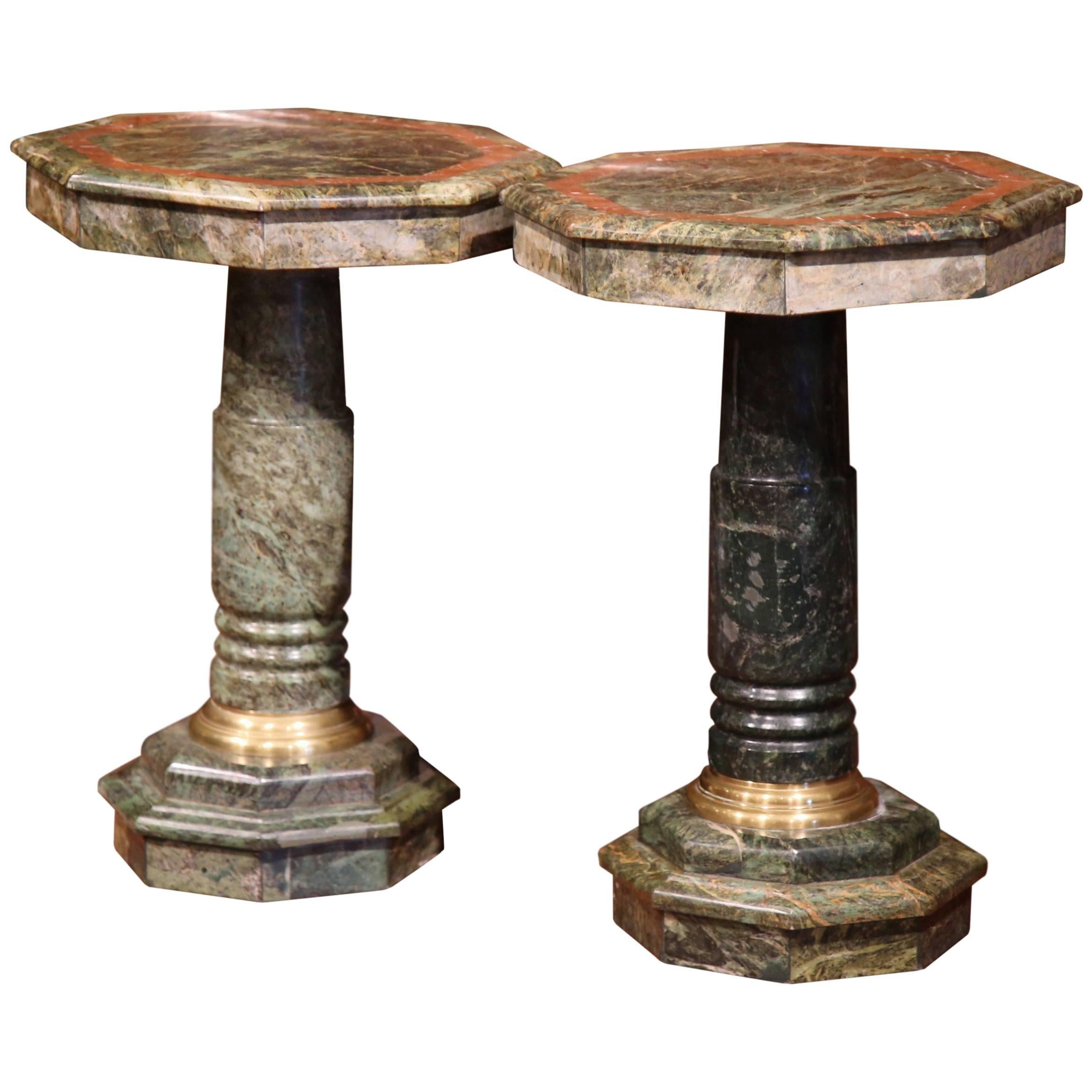 This elegant pair of antique marble pedestal tables were created in Italy, circa 1890. The heavy, sturdy pedestals have a carved base with decorative brass mounts at the neck and bottom, and feature an octagonal green marble top with a inset brown