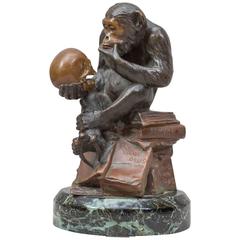 Figure fantaisiste en bronze d'un singe étudiant un crâne:: référence darwinienne