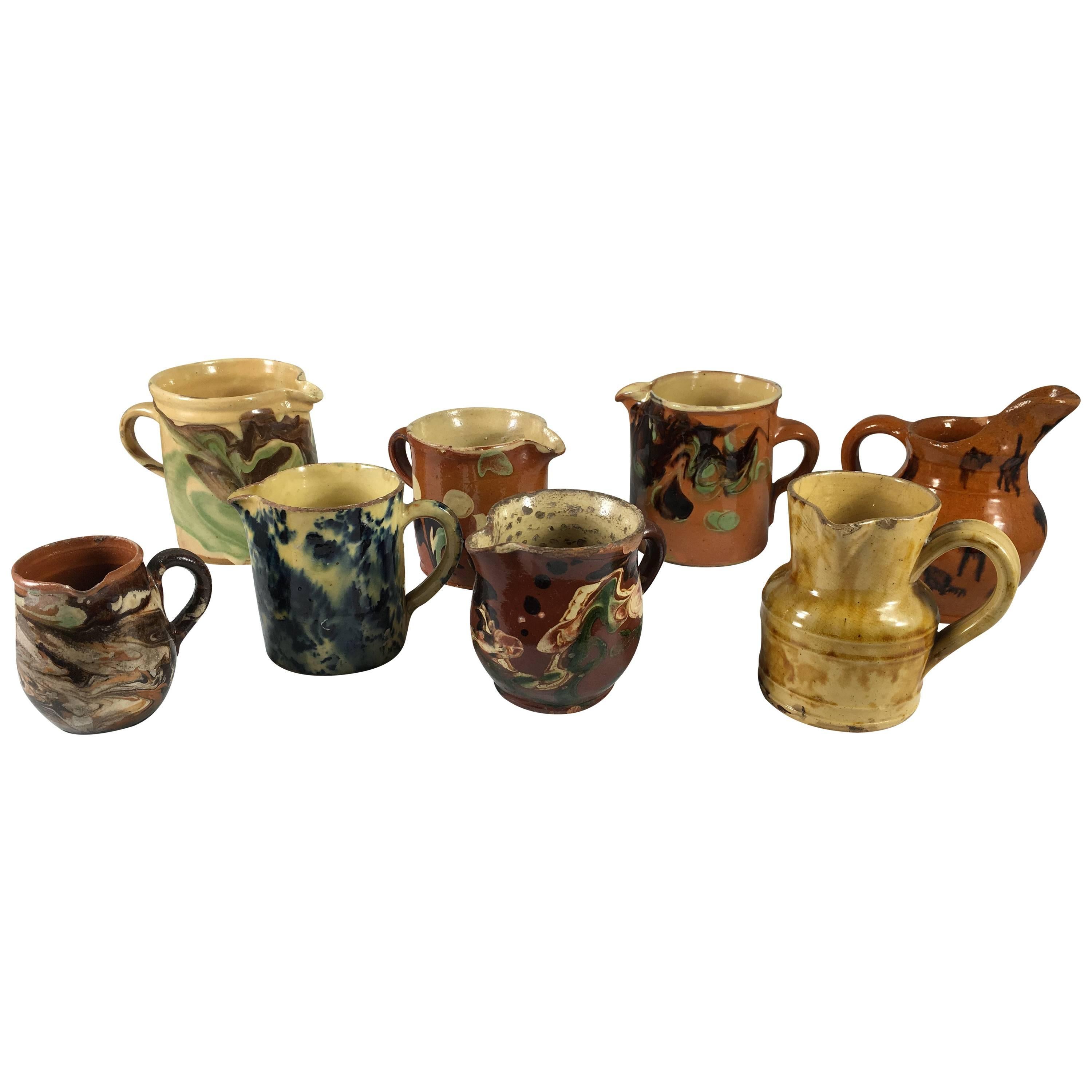 Collection of Eight Small French Provincial Jaspe Cream Pitchers, 19th Century