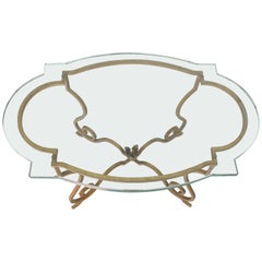Mesa auxiliar ovalada con base de hierro dorado forjado y cristal figurado