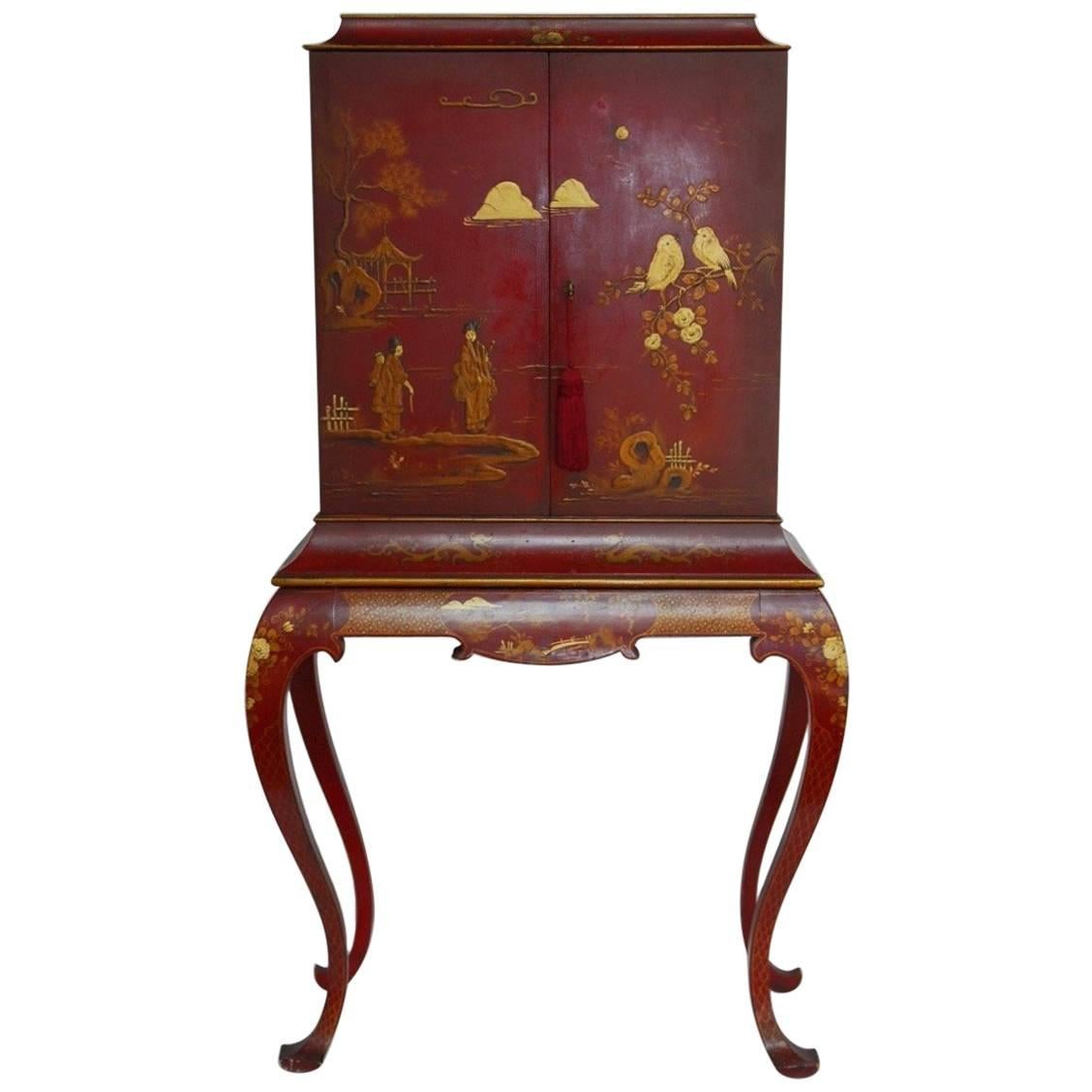 Fantastic chinoiserie red lacquer cocktail cabinet or dry bar on stand featuring a gilt Japanned case decorated with scenic reserves of dragons, pagodas and birds. Fronted by two large doors that open to a fitted interior with three drawers. The