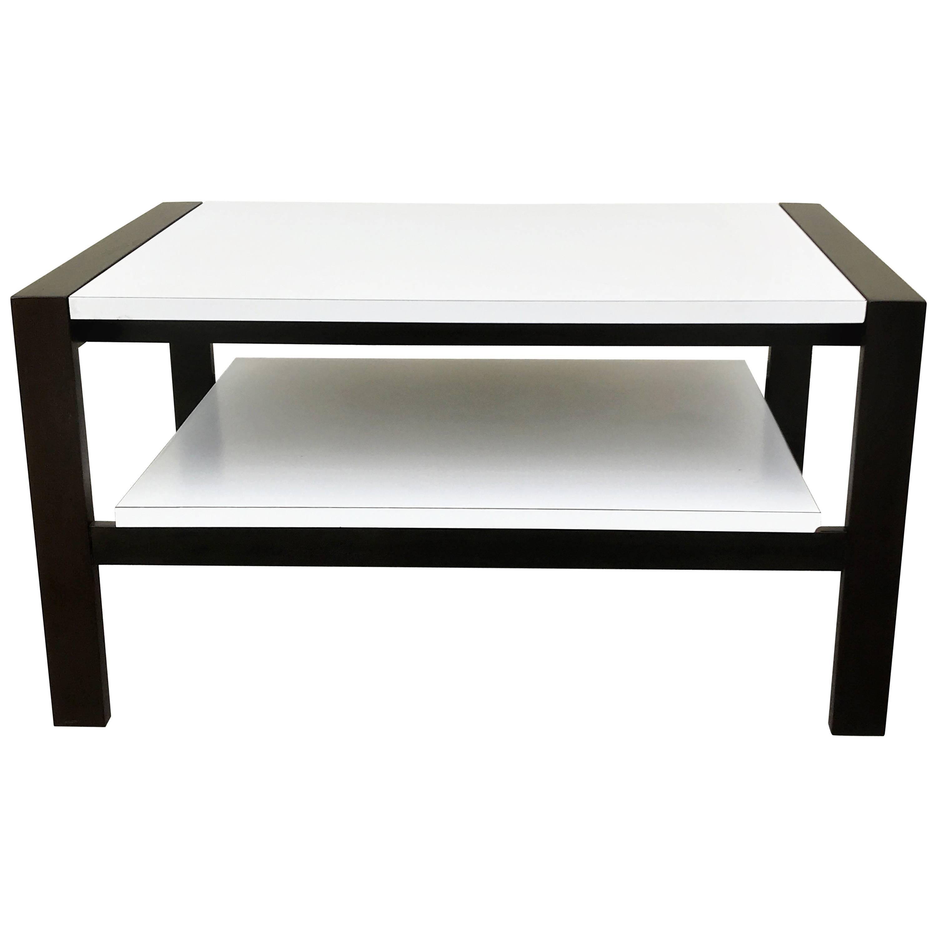 This white formica and dark stained mahogany coffee table features two tiers. The bottom shelf can be pulled out and adjusted at the required length as visible in our 2nd photo. The wood frame of the table has been newly refinished in an espresso